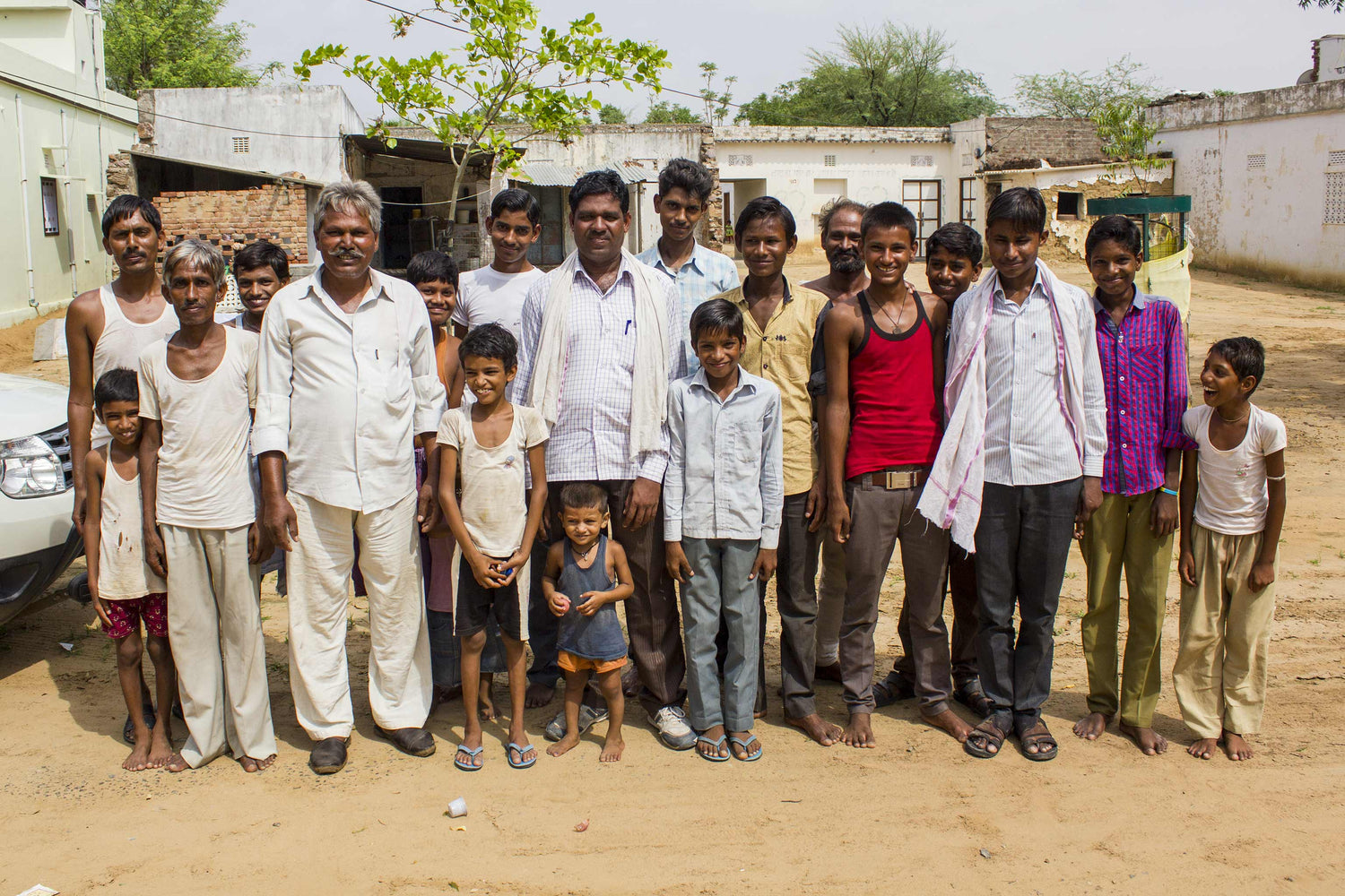 a group photo of weavers and young kids from an Indian Rajasthani village.