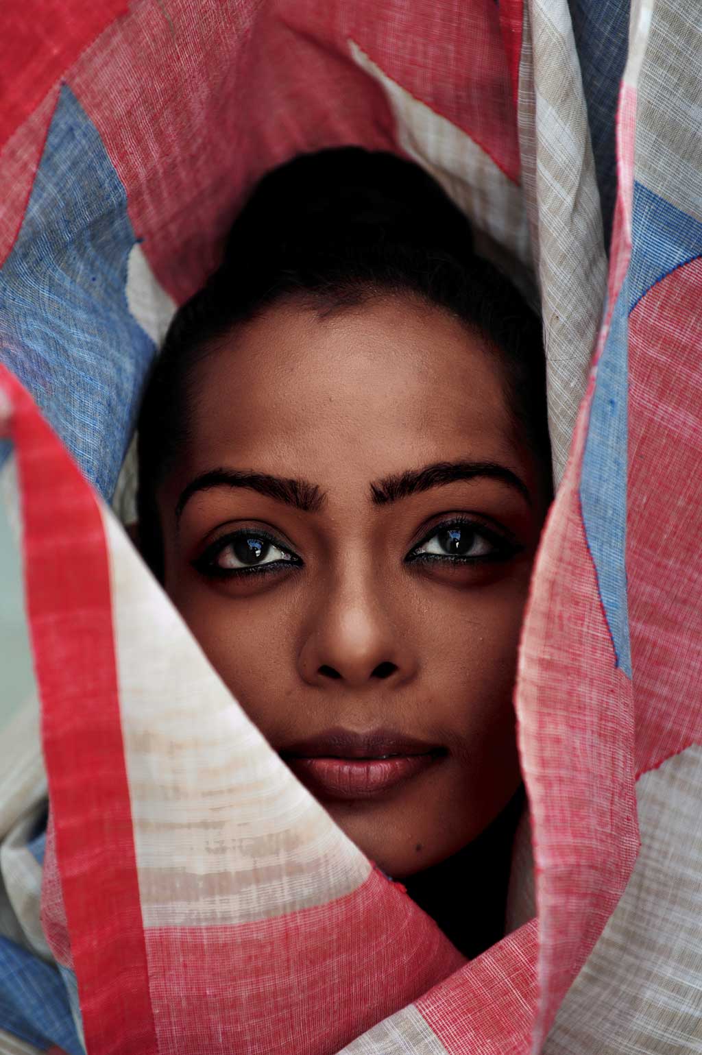 face of Kamakshi Saxena looking through wrapped in Khadi Jamdani Red Blue Saree