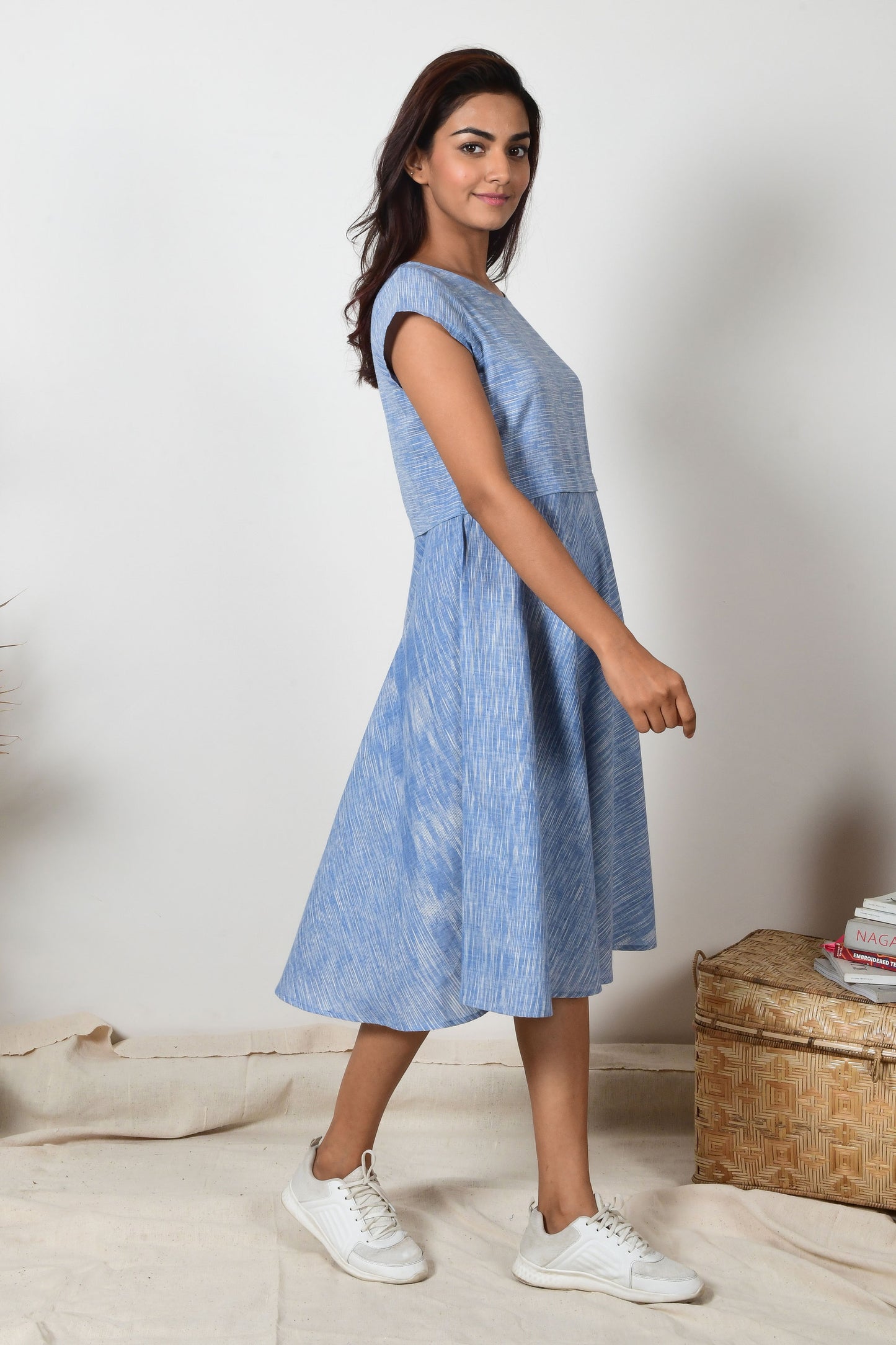 side posing Indian girl wearing a blue cotton a-line dress made specially for summers.