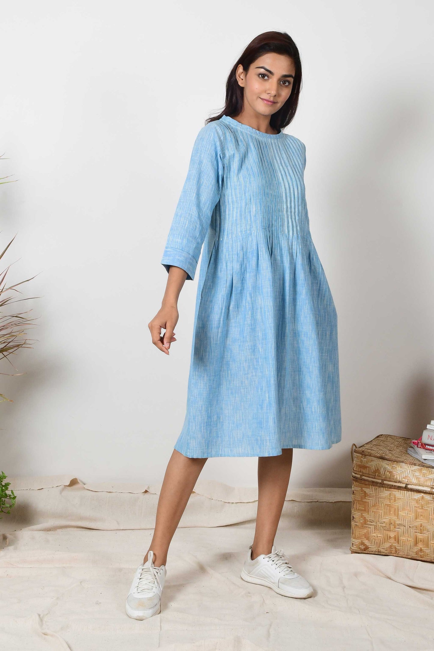 Indian girl wearing sky blue cotton pleated dress with a pair of white sneakers