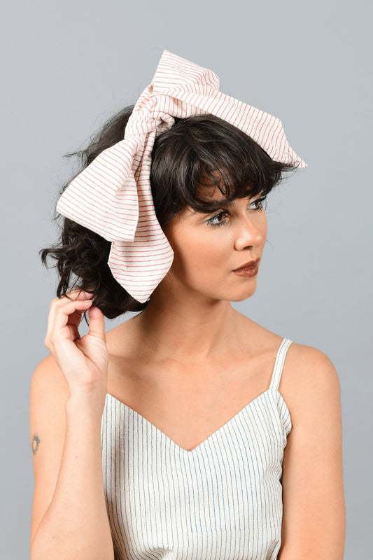 front of a model wearing a bandana tied as bow on the head printed with fine red stripes using brass block over handspun handwoven khadi cotton from maheshwar