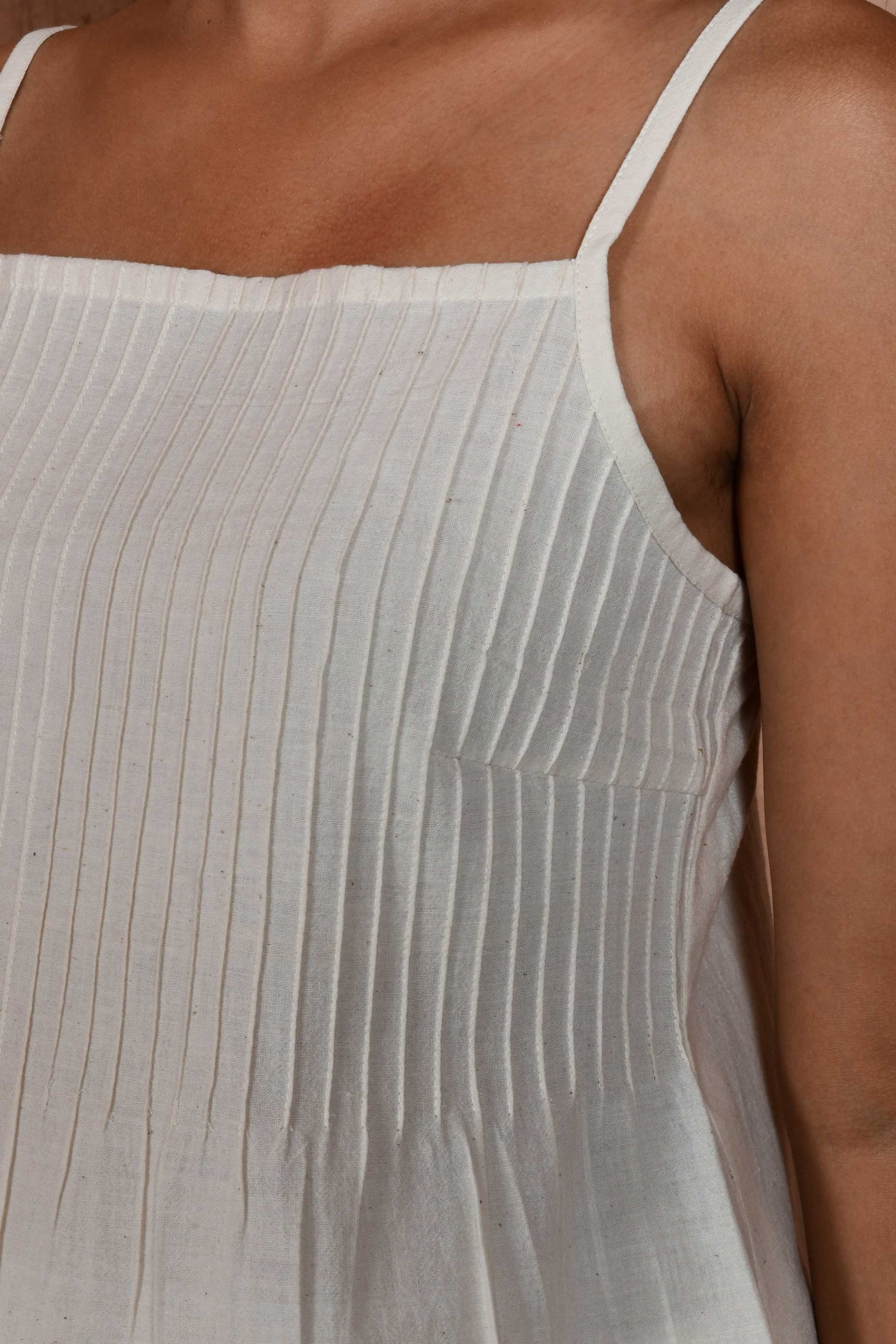 Close up of front of the pin tucks on an off white spaghetti top.