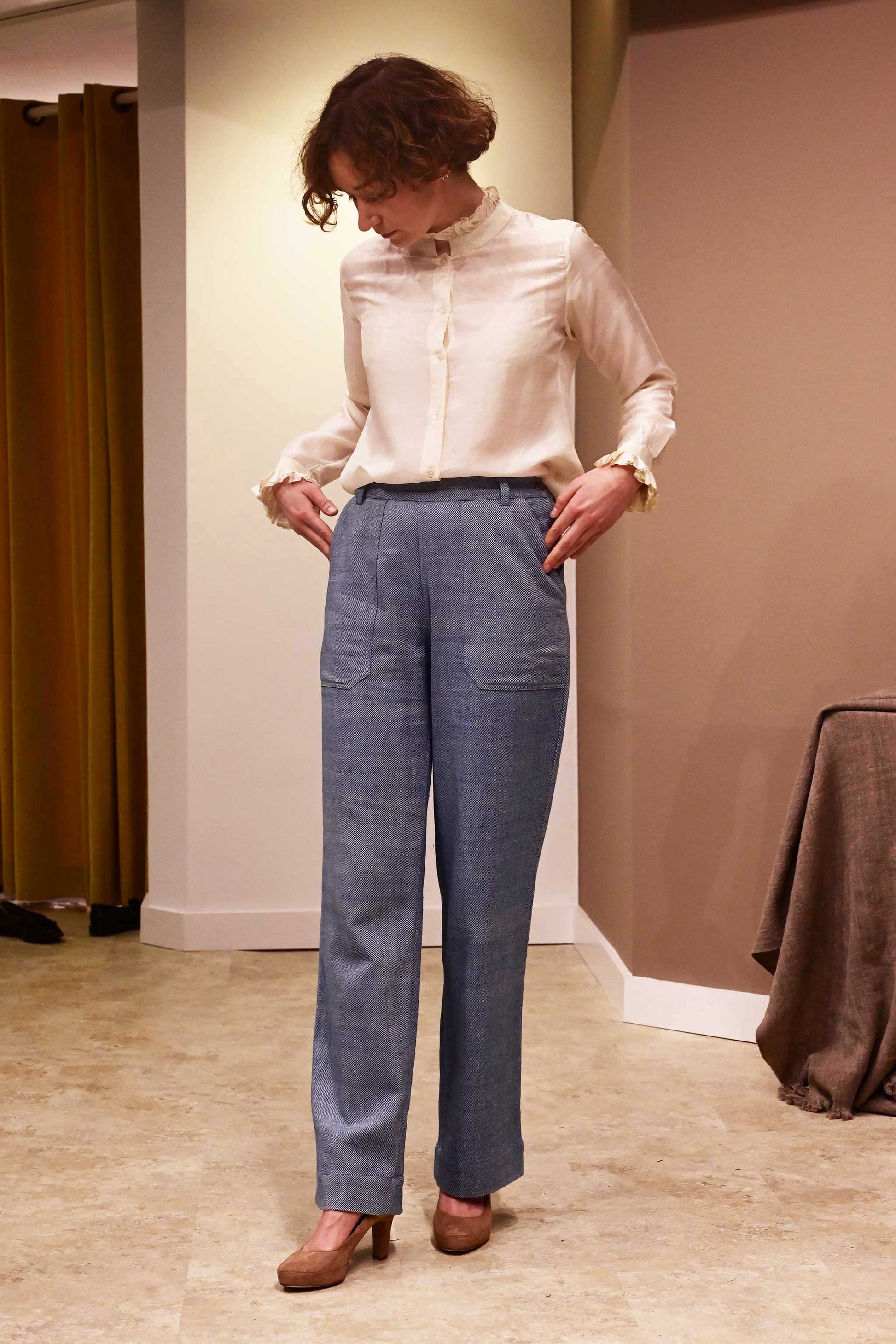 Front of a model wearing white silk shirt and natural indigo dyed blue denims that is made if handspun and handwoven kala cotton from India.