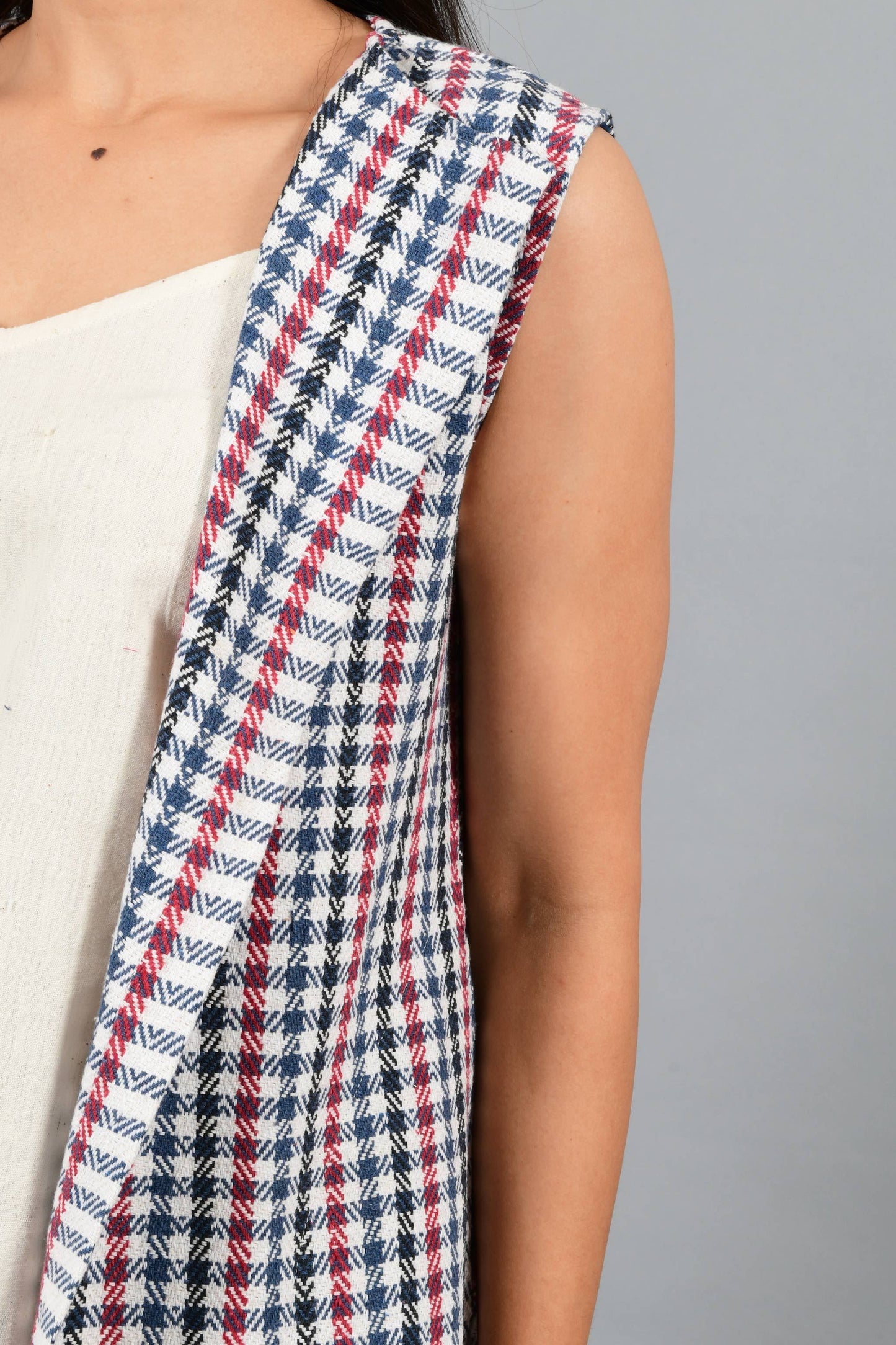 Front close up of an Indian Womenswear female model wearing Red and Blue handspun and handwoven khadi long Jacket over an off-white cashmere cotton dress by Cotton Rack.