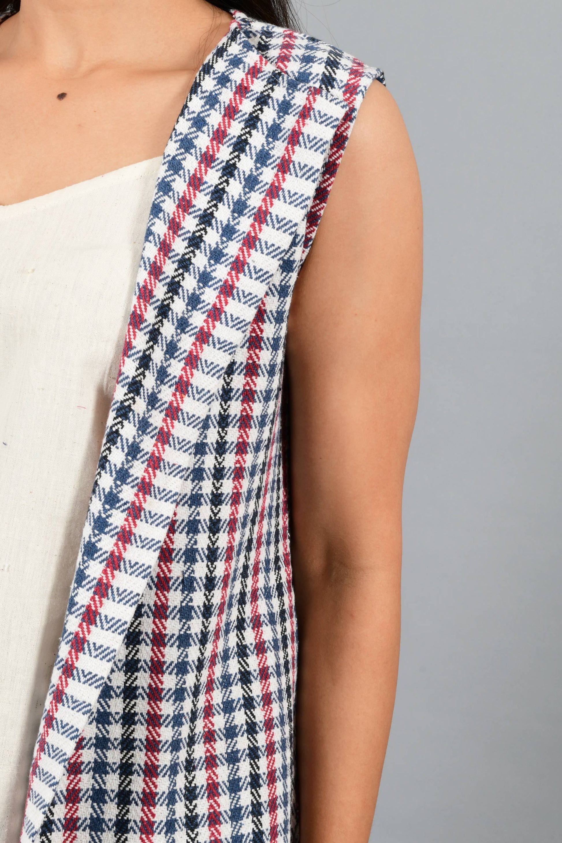Front close up of an Indian Womenswear female model wearing Red and Blue handspun and handwoven khadi long Jacket over an off-white cashmere cotton dress by Cotton Rack.