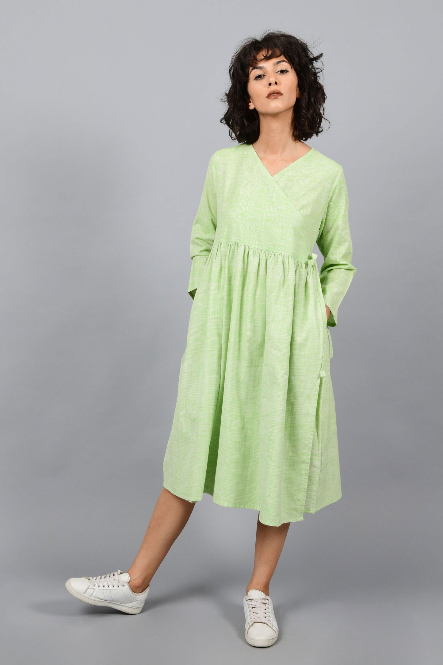 front of a model wearing an angrakha dress kurta in green and white space dyed fine handspun handwoven khadi cotton from west bengal