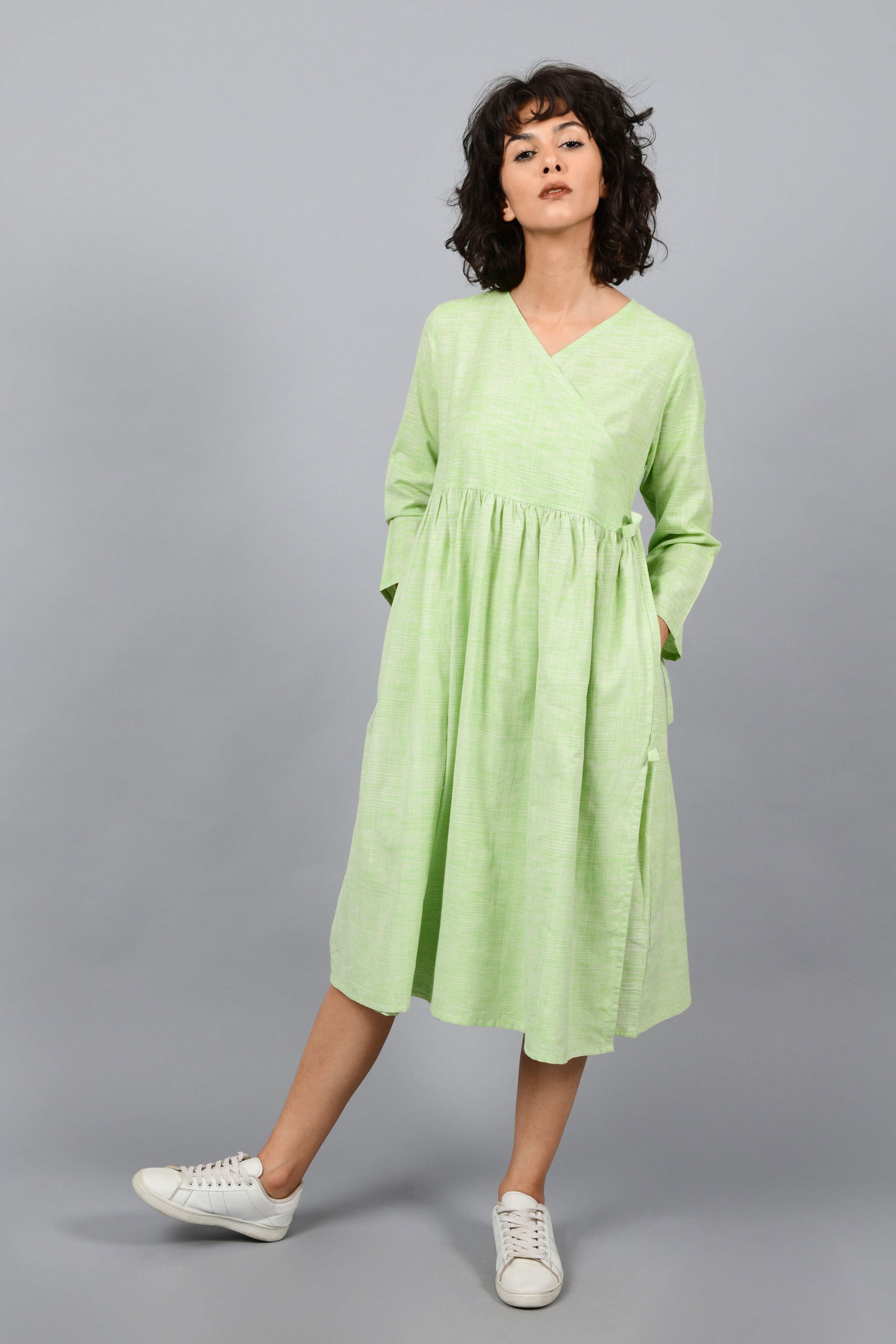 front of a model wearing an angrakha dress kurta in green and white space dyed fine handspun handwoven khadi cotton from west bengal