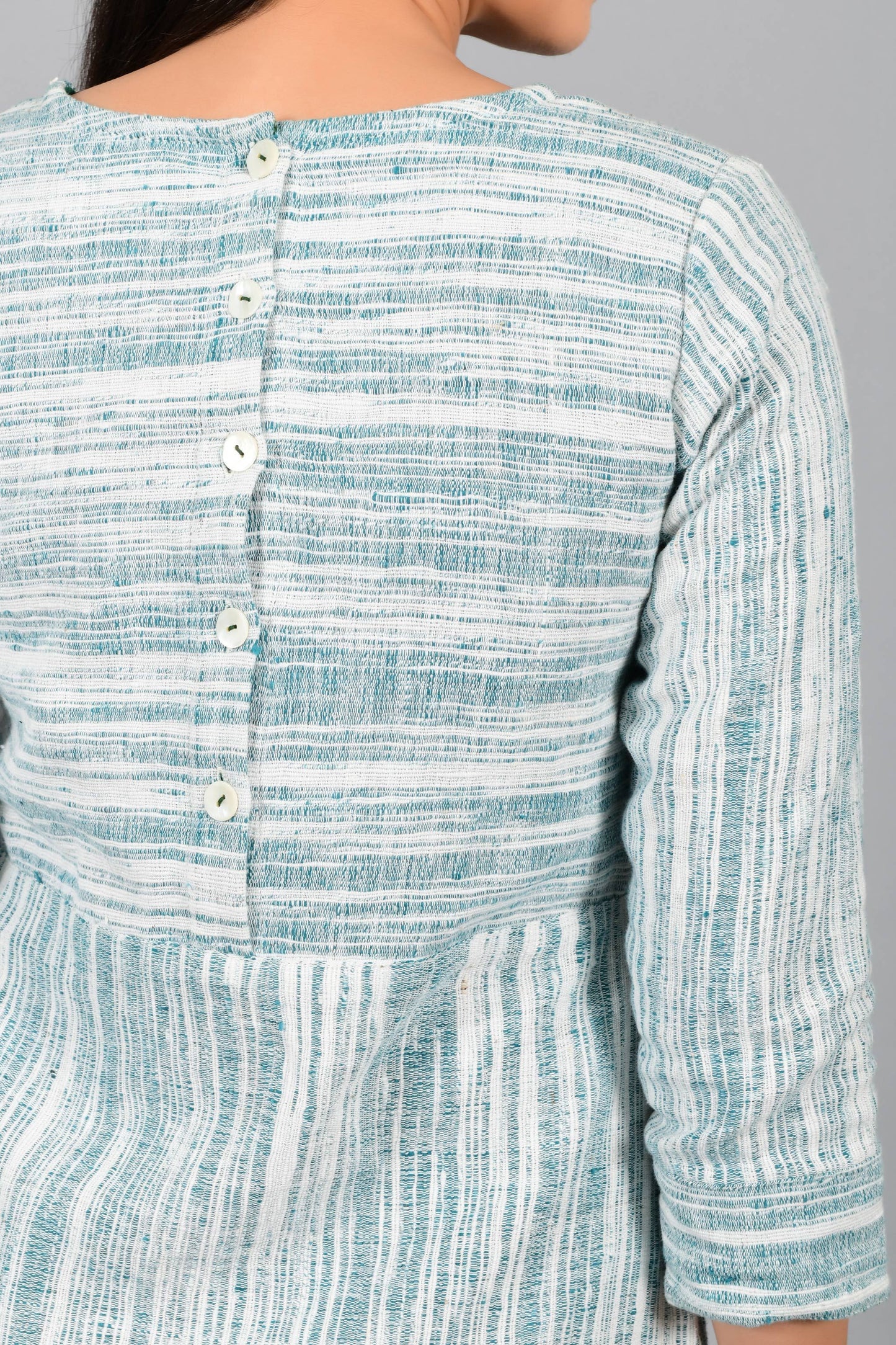 Back button detail of an Indian Womenswear female model wearing pine green handspun and handwoven cotton dress by Cotton Rack.