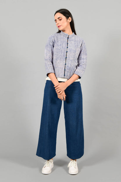 Front pose of an Indian Womenswear female model wearing Indigo Blue Gandhi Charkha spun and handwoven khadi buttoned mandarin collar Jacket over an off-white spaghetti and indigo palazzos by Cotton Rack.