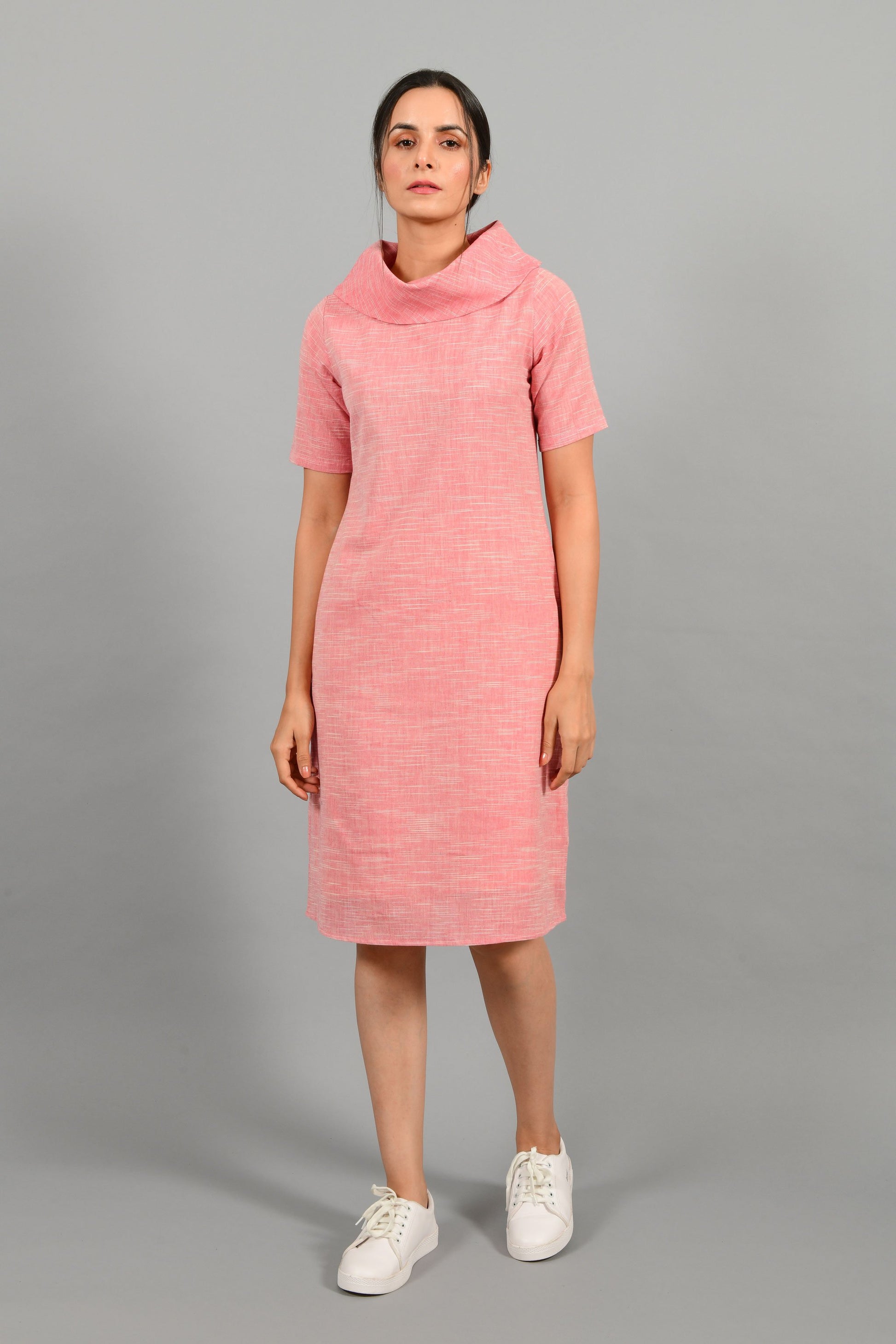 Front pose of an Indian female womenswear fashion model in a Pink and White space dyed cowl neck, elbow sleeve handspun and handwoven khadi cotton dress by Cotton Rack.