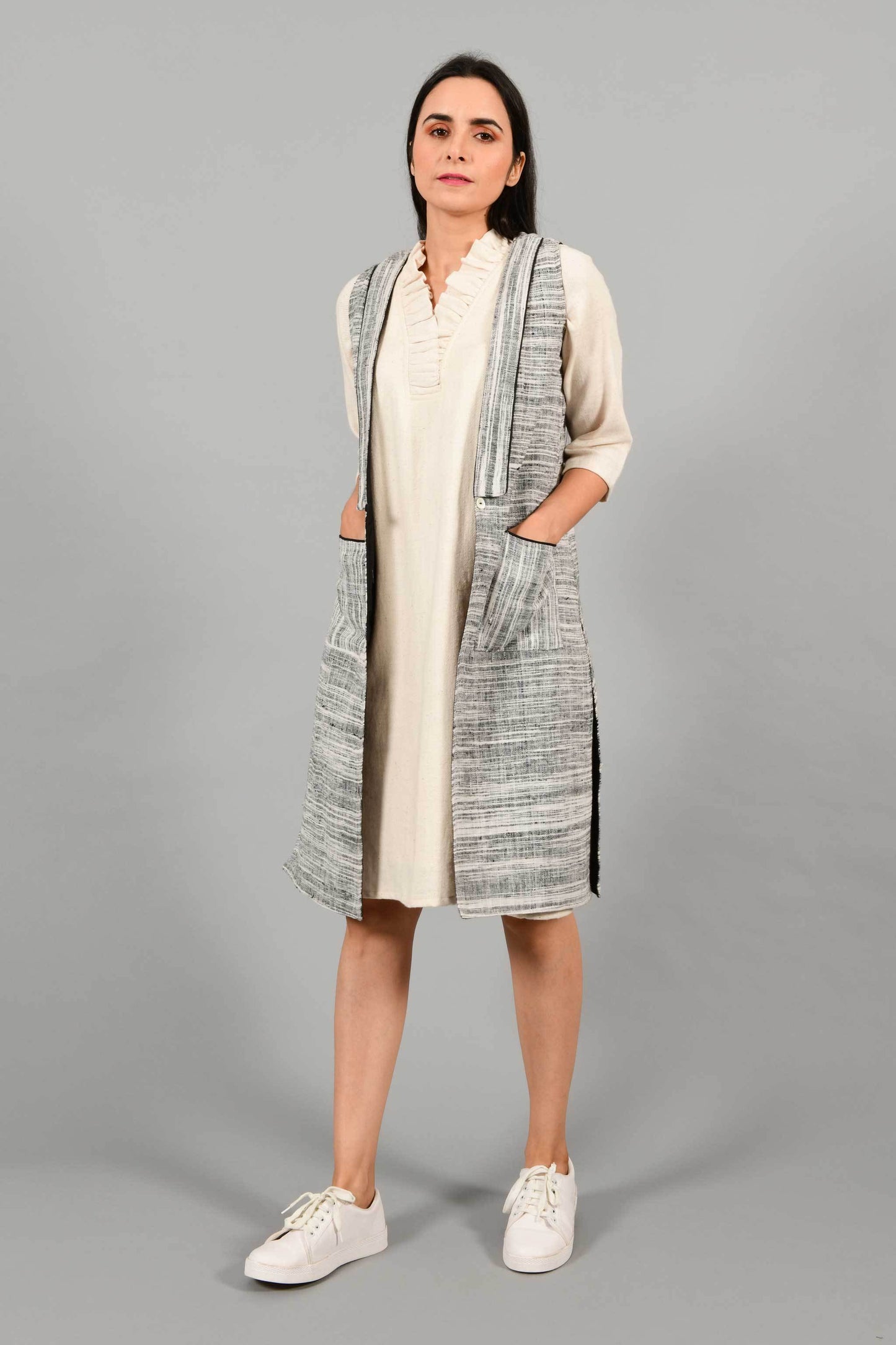 Front pose of an Indian Womenswear female model wearing black and white thicker handspun and handwoven khadi Jacket over a Cashemer Cotton Dress by Cotton Rack.