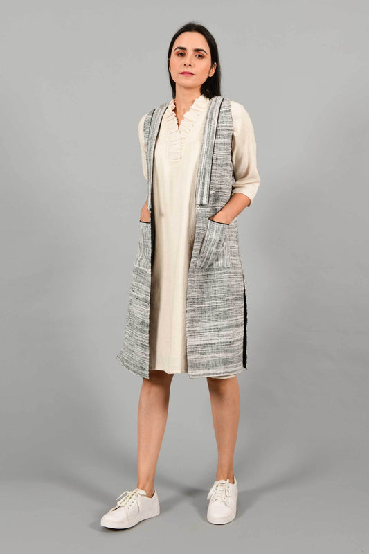 Front pose of an Indian Womenswear female model wearing black and white thicker handspun and handwoven khadi Jacket over a Cashemer Cotton Dress by Cotton Rack.