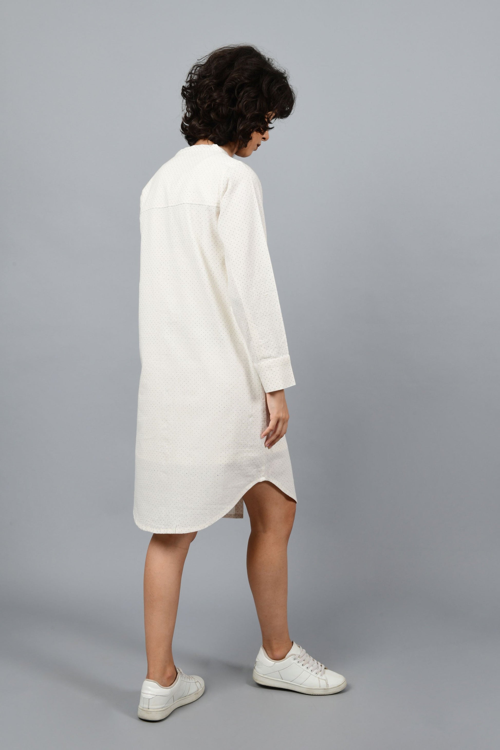 back of a womenswear fashion model wearing a minimalistic front open shirt dress printed with fine contrasting details and with blue dots using brass block printing over handspun handwoven khadi cotton from maheshwar by Cotton Rack
