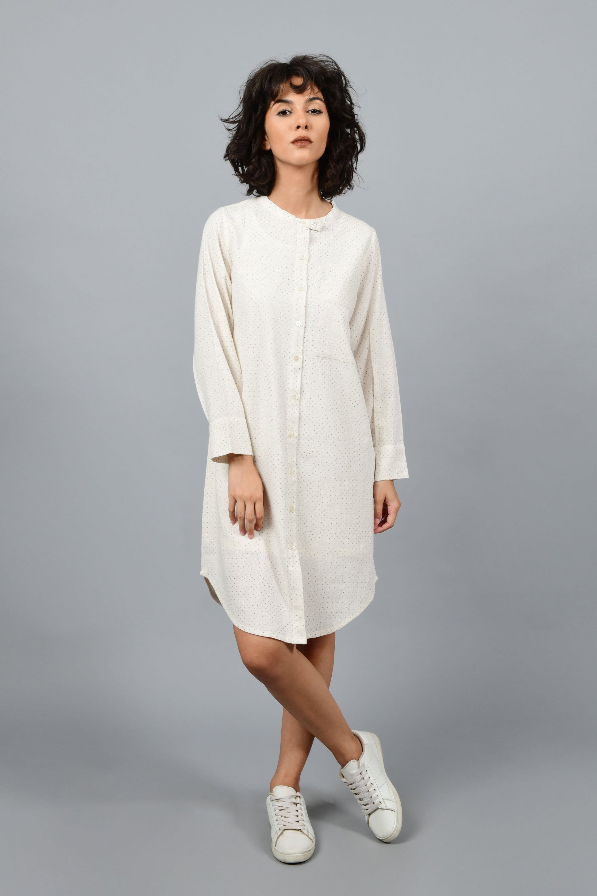 front of a womenswear fashion model wearing minimally designed front open shirt dress by cotton rack printed with fine contrasting details and with blue dots using brass block printing over handspun handwoven khadi cotton from maheshwar