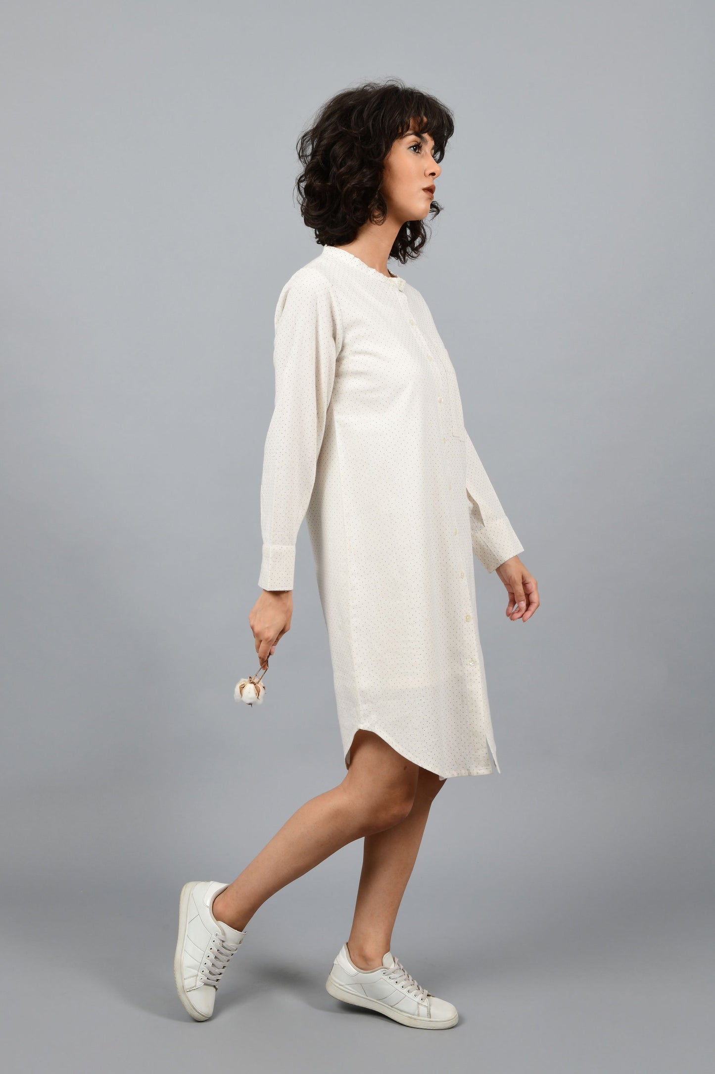 side pose of a womenswear fashion model wearing minimalistic a front buttoned western shirt dress printed with fine contrasting details and with blue dots using brass block printing over handspun handwoven khadi cotton from maheshwar by cotton rack