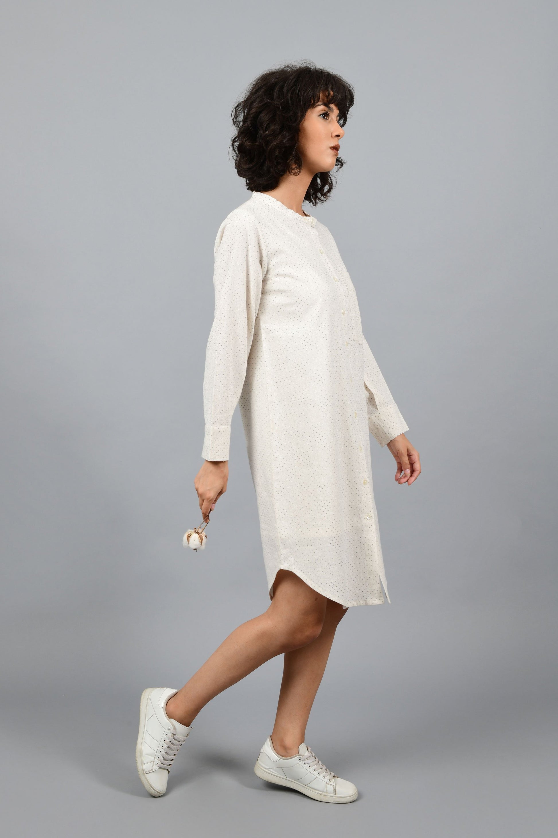 side pose of a womenswear fashion model wearing minimalistic a front buttoned western shirt dress printed with fine contrasting details and with blue dots using brass block printing over handspun handwoven khadi cotton from maheshwar by cotton rack