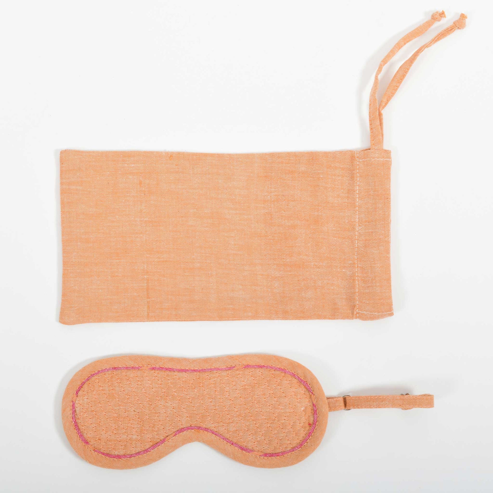 A close-up image from the top of the orange chambray eye mask and it's co-ordinated cover made in handspun and handwoven khadi cotton by Cotton Rack.