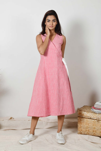 A young Indian female model wearing a sleeveless cotton dress of pink color made with hand spun and hand woven cotton.