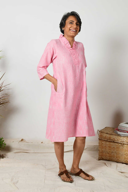 smilling short haired indian woman wearing baby pink flared neck Kurta dress made using hand spun hand woven cotton.