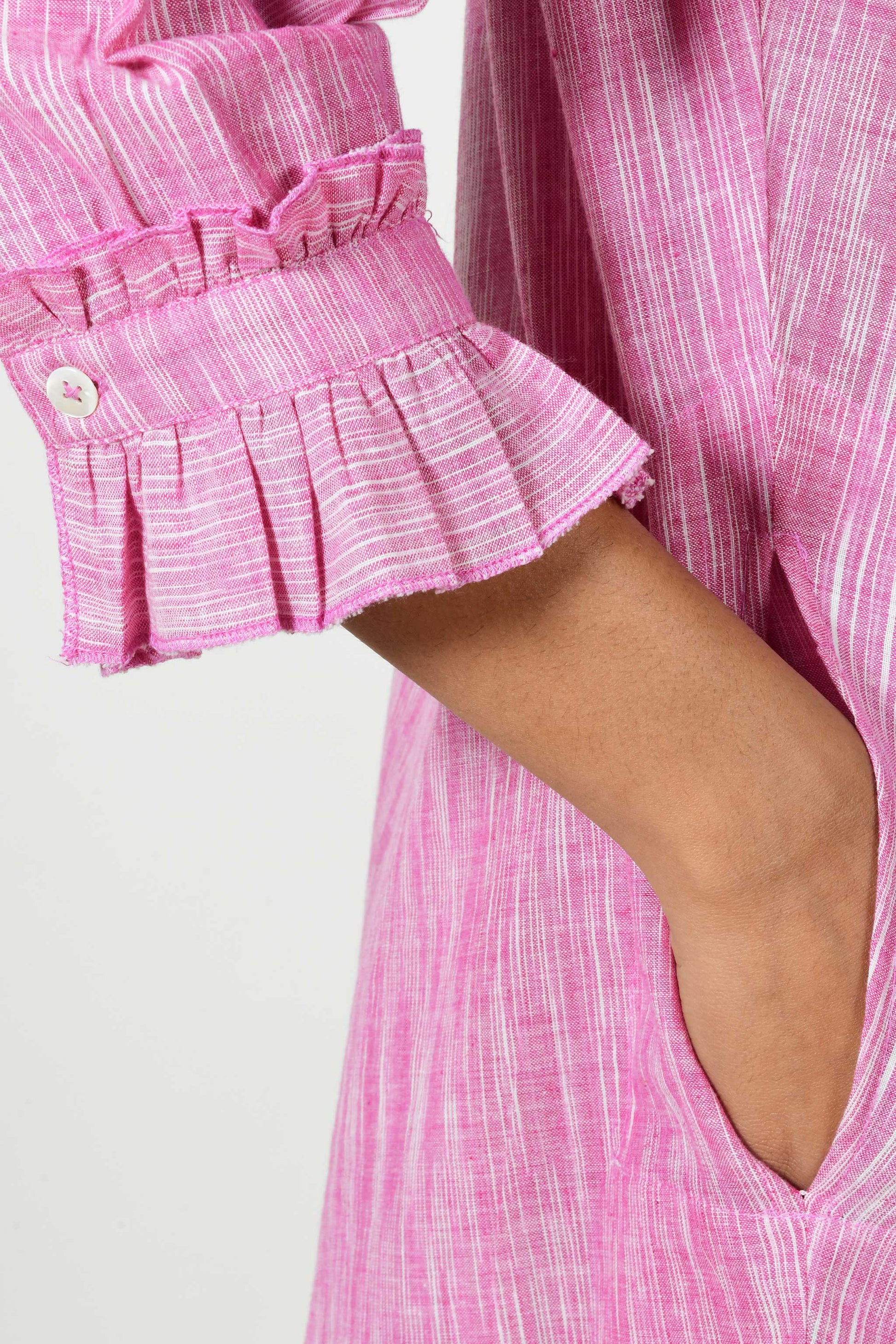 close up of ruffled sleeve cuff of space dyed pink cotton.