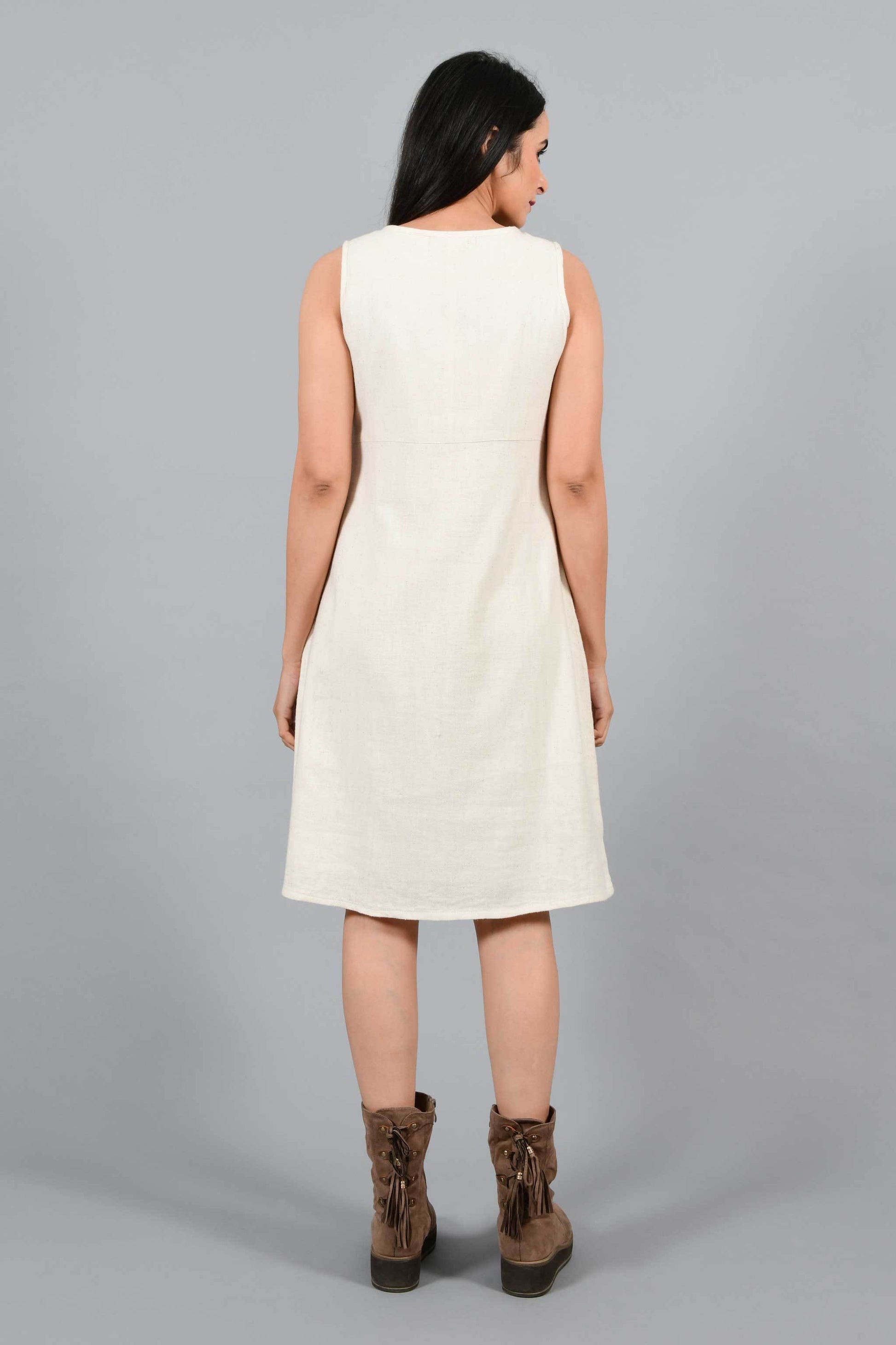Back pose of an Indian female womenswear fashion model in an off-white Cashmere Cotton Pleated Dress made using handspun and handwoven khadi cotton by Cotton Rack.