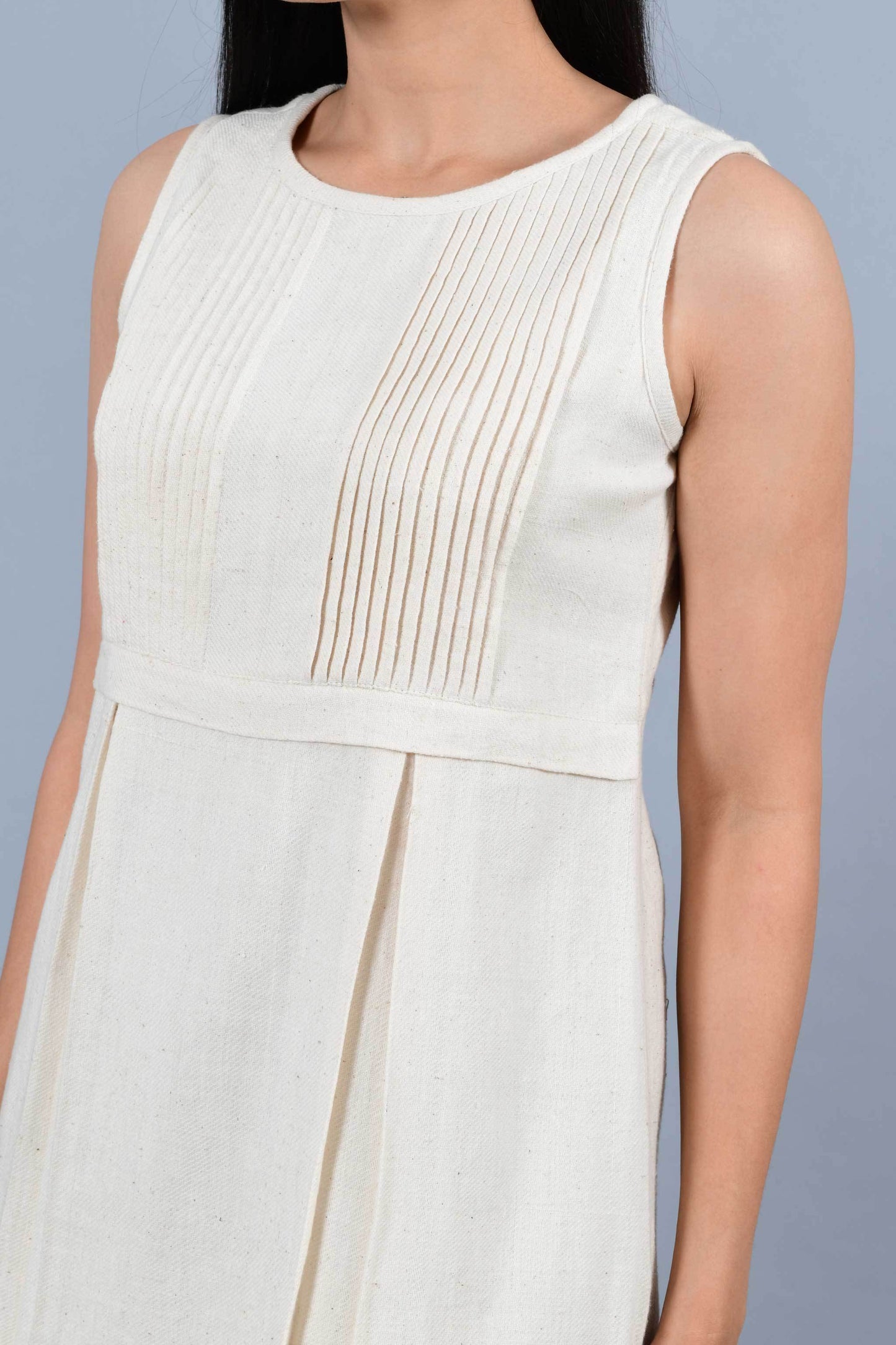 Close Up of an Indian female womenswear fashion model in an off-white Cashmere Cotton Pleated Dress made using handspun and handwoven khadi cotton by Cotton Rack.