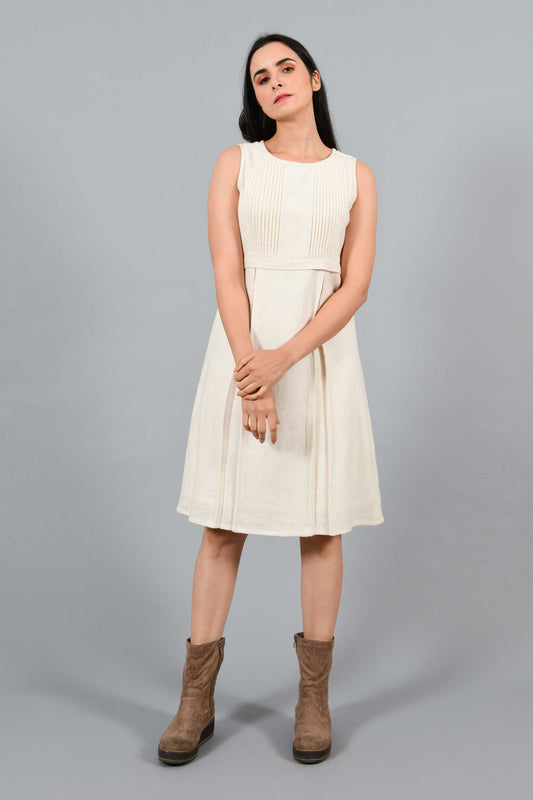 Stylised front pose of an Indian female womenswear fashion model in an off-white Cashmere Cotton Pleated Dress made using handspun and handwoven khadi cotton by Cotton Rack.