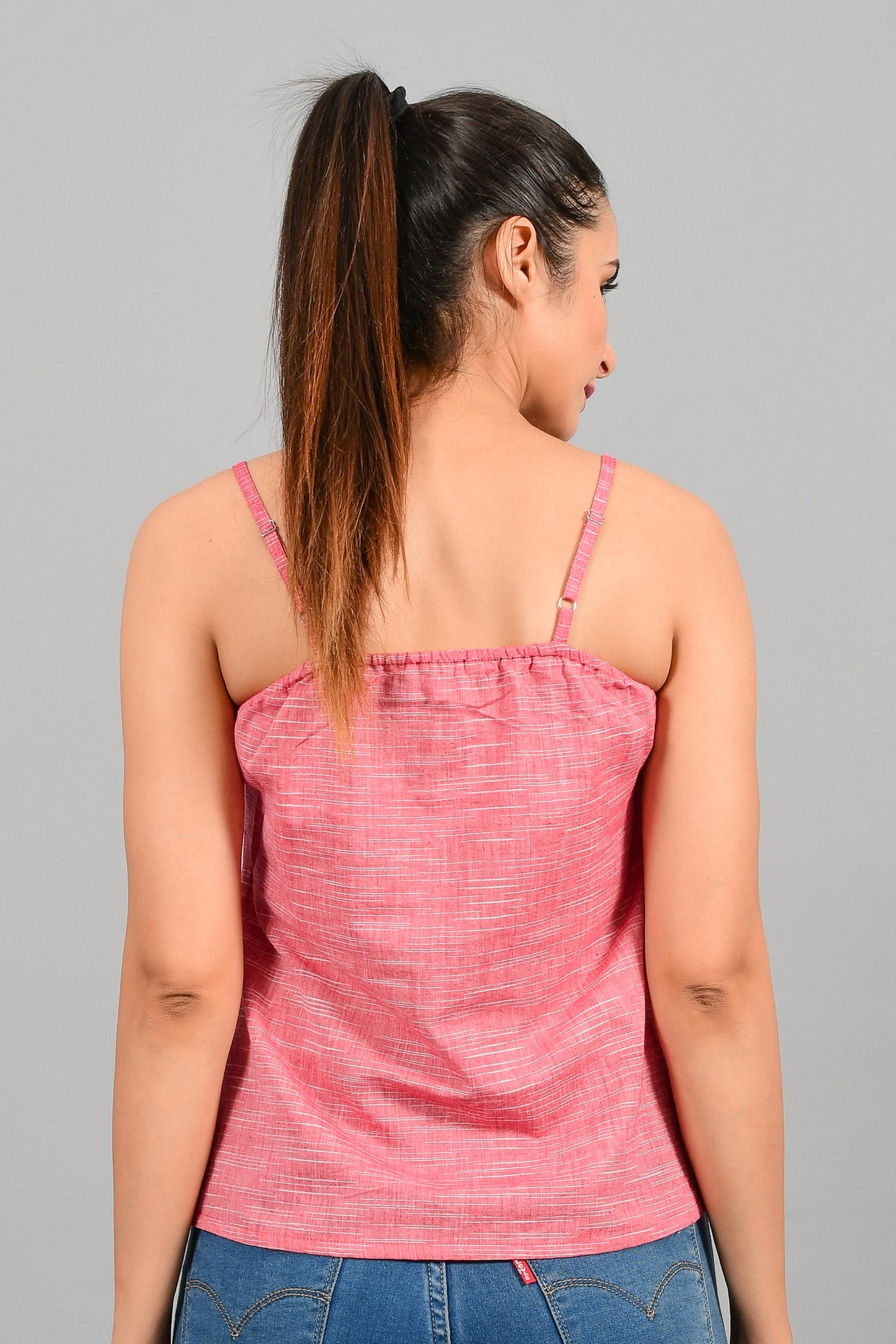 Back pose of an Indian female womenswear fashion model in a space dyed red spaghetti made with handspun and handwoven khadi cotton by Cotton Rack.