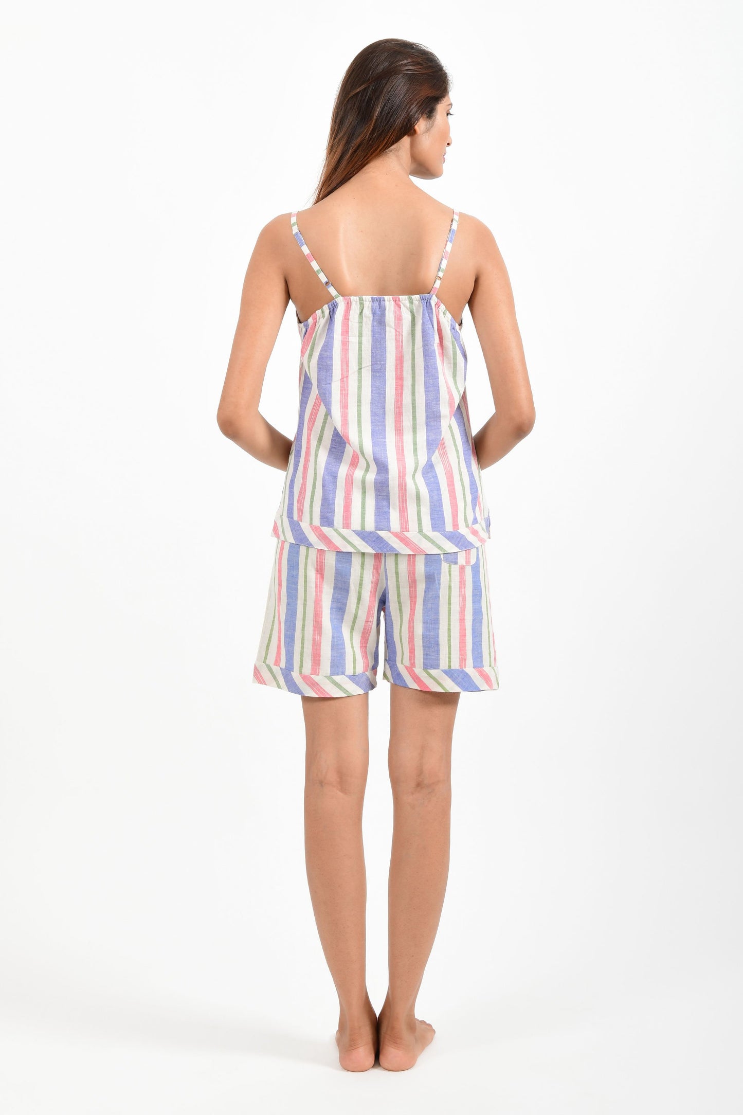 Back pose of an Indian female womenswear fashion model in azo-free candy colour striped, handspun and handwoven khadi cotton spaghetti top and boxers by Cotton Rack.