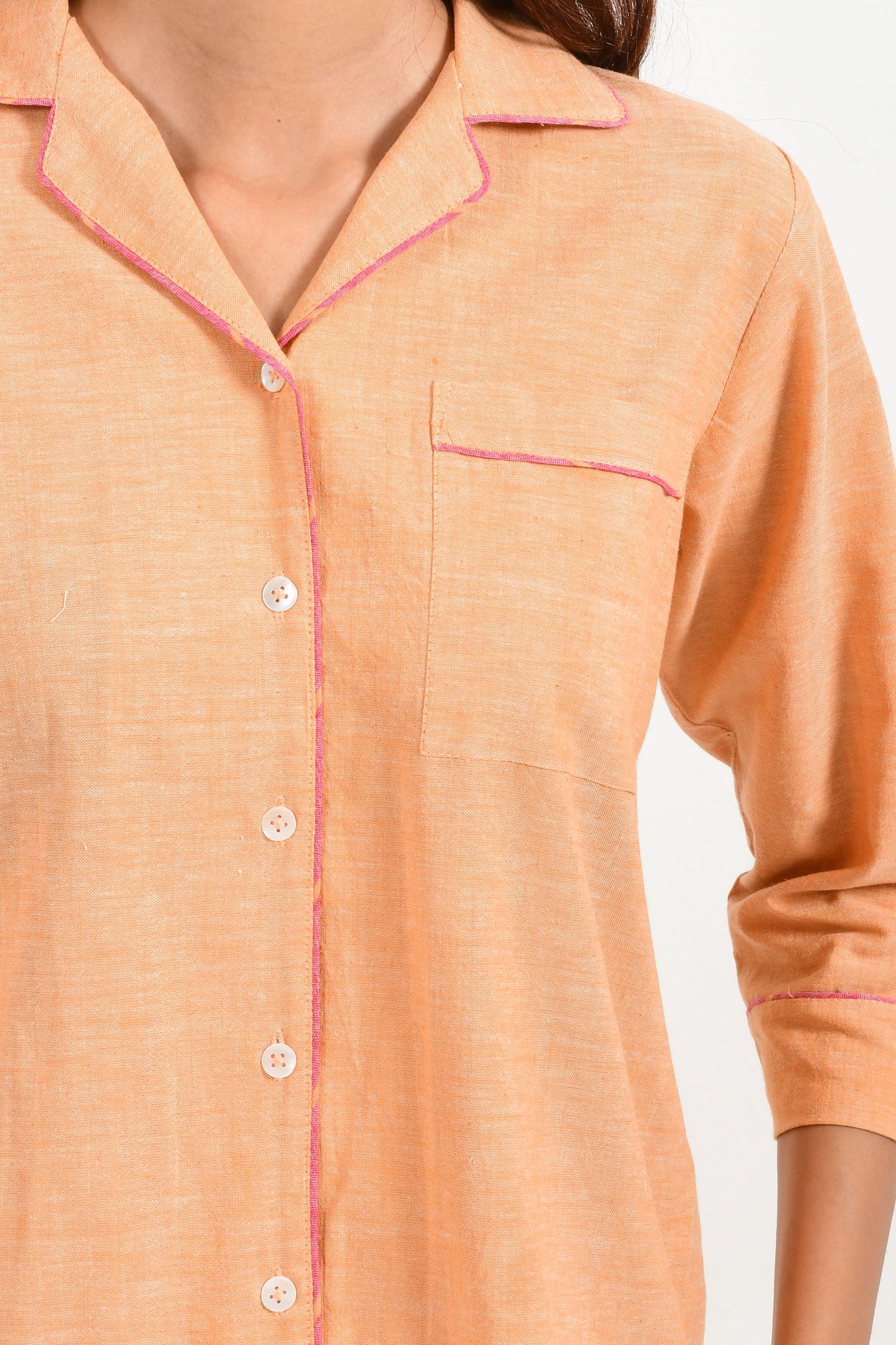 Close-Up of an Indian female womenswear fashion model in azo-free dyed handspun and handwoven khadi cotton nightwear pyjama & shirt in orange chambray by Cotton Rack.