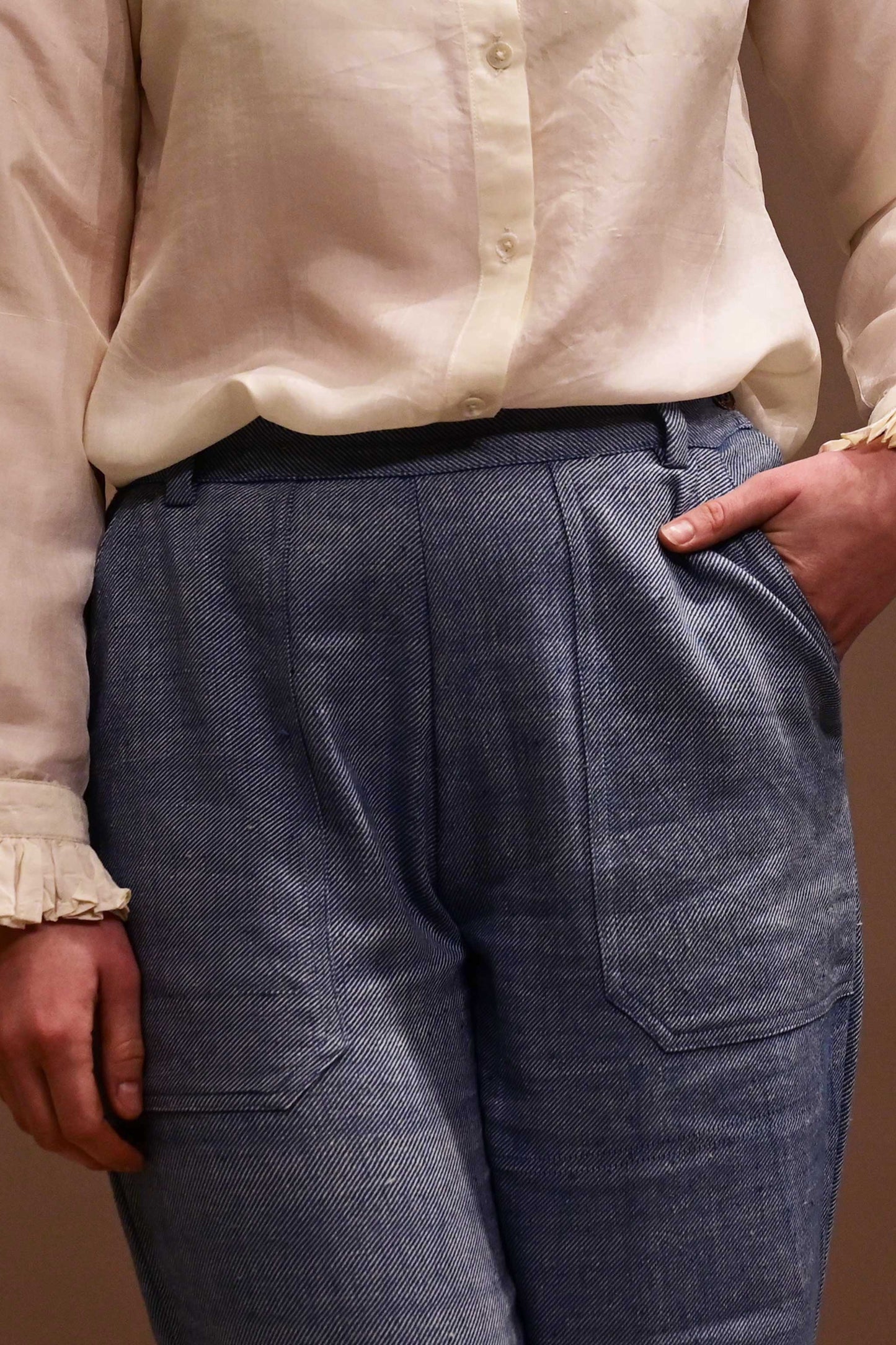 Close up of front patch pockets of natural indigo dyed blue denims that is made if handspun and handwoven kala cotton from India.