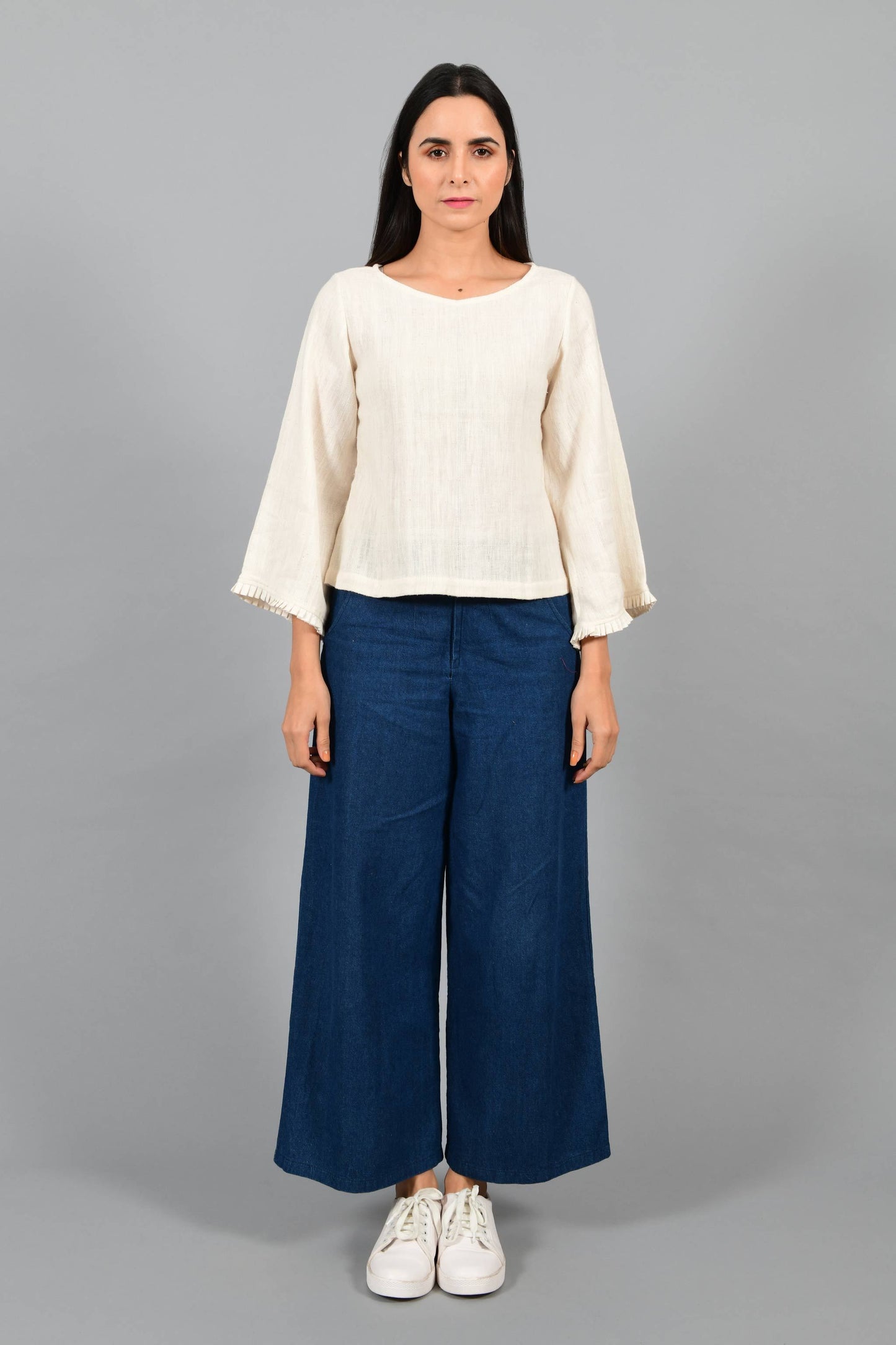 Front pose of an Indian female womenswear fashion model in an off-white Cashmere Cotton Top with bell sleeves made using handspun and handwoven khadi cotton by Cotton Rack.