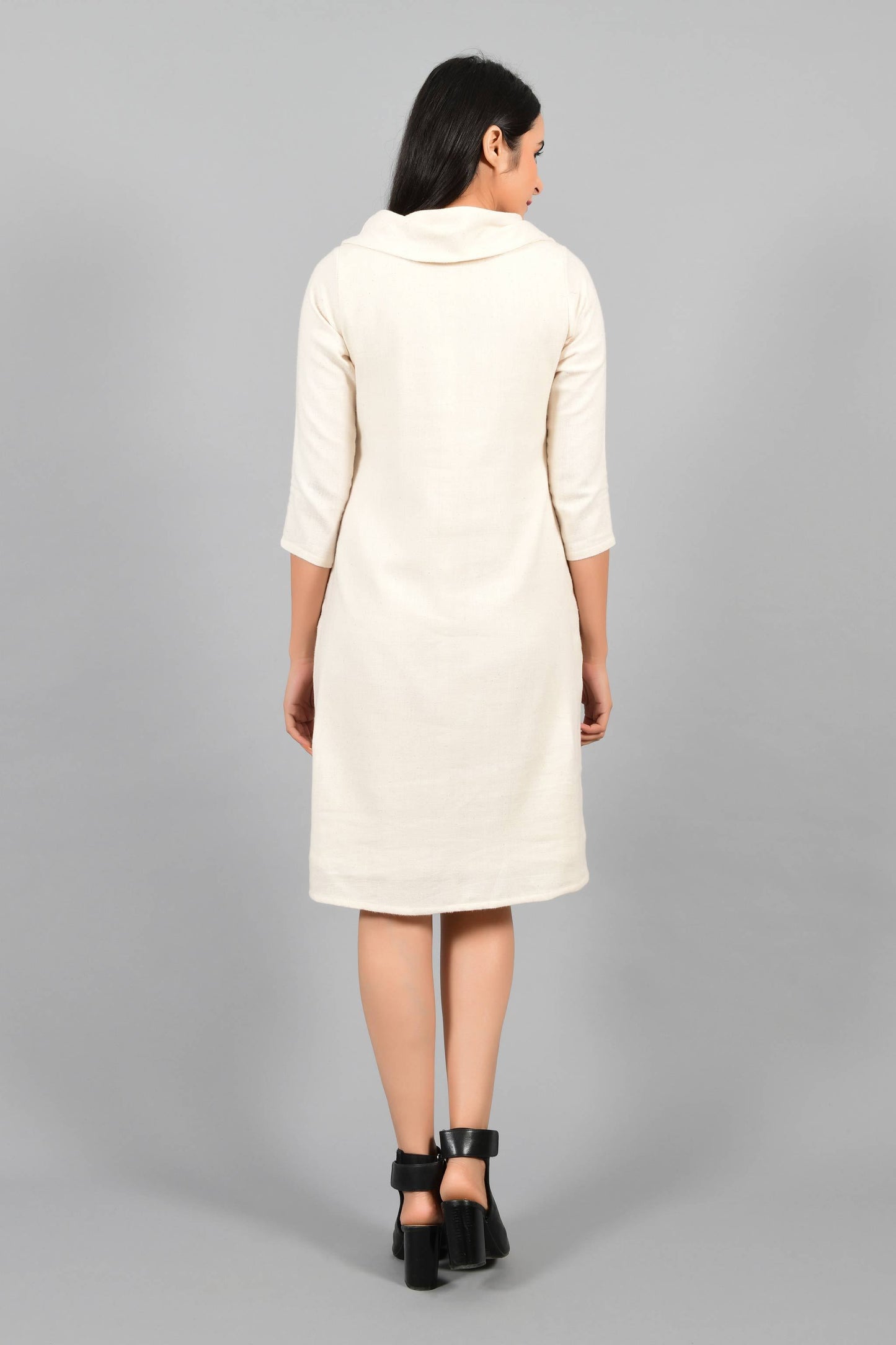 Back pose of an Indian female womenswear fashion model in an off-white Cashmere Cotton Cowl Neck Dress made using handspun and handwoven khadi cotton by Cotton Rack.