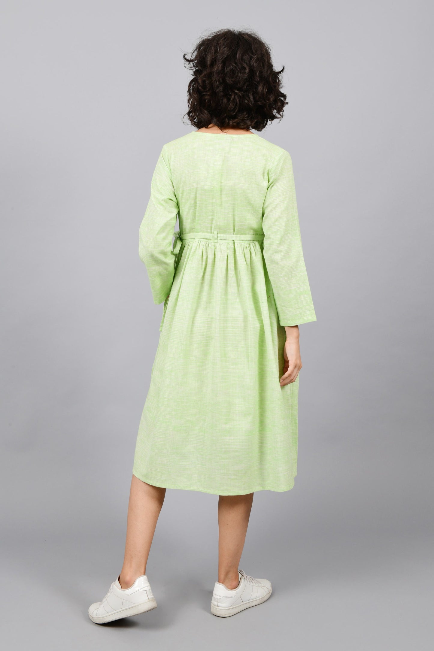 back of a model wearing an angrakha dress kurta in green and white space dyed fine handspun handwoven khadi cotton from west bengalv