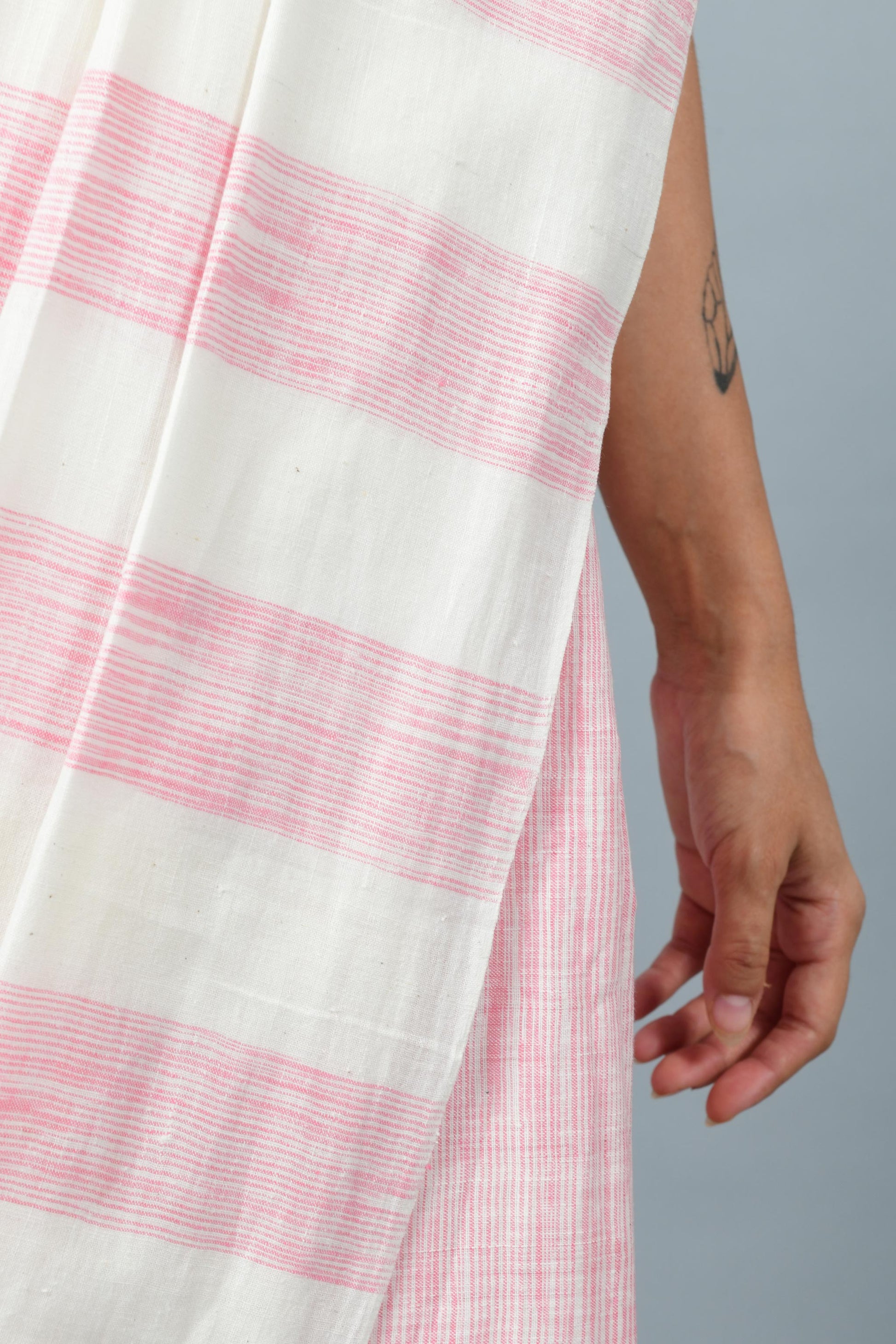 Close-Up pose of a female womenswear fashion model draped in a pink & white space dyed homespun and handwoven cotton saree by Cotton Rack.