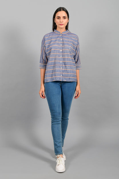 Front pose of an Indian female womenswear fashion model in a blue chambray with orange stripes handspun and handwoven khadi cotton free size top by Cotton Rack.