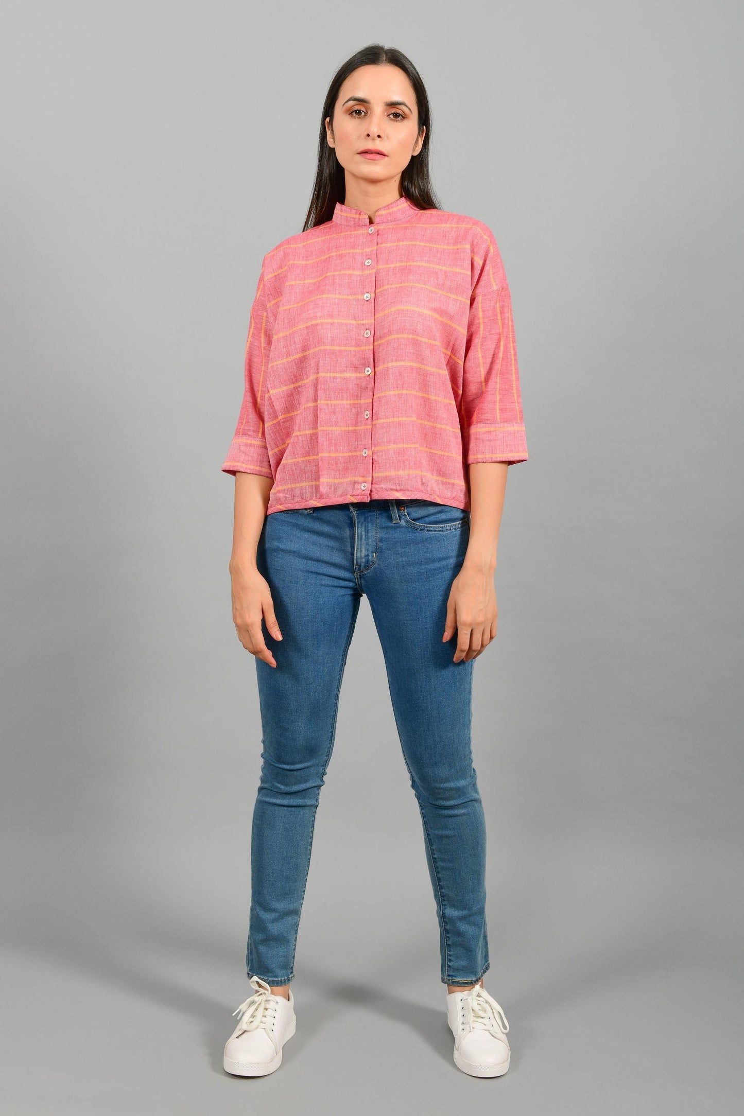 Front pose of an Indian female womenswear fashion model in a red chambray with orange stripes handspun and handwoven khadi cotton free size top by Cotton Rack.