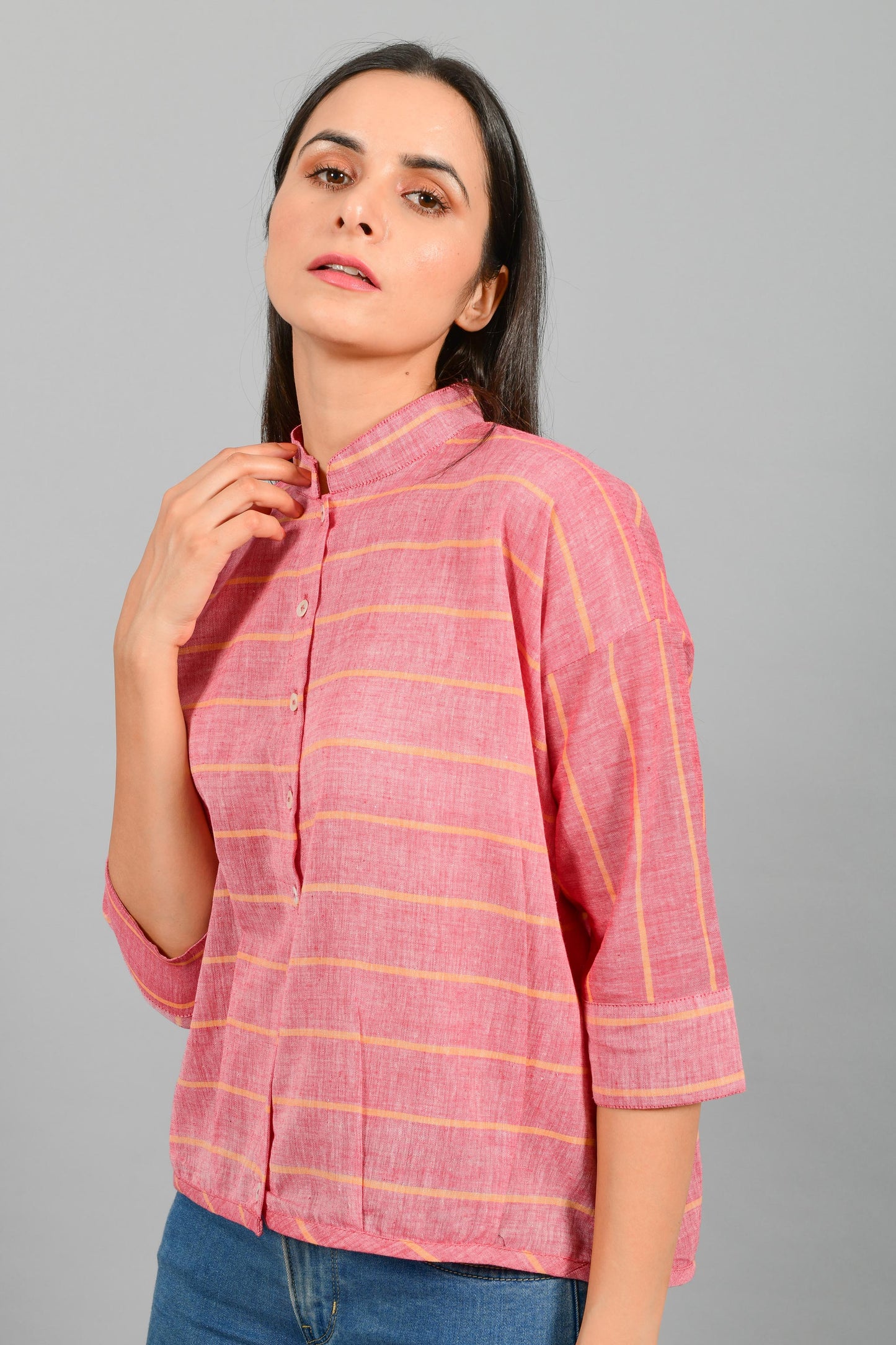Close Up portrait of an Indian female womenswear fashion model in a red chambray with orange stripes handspun and handwoven khadi cotton free size top by Cotton Rack.
