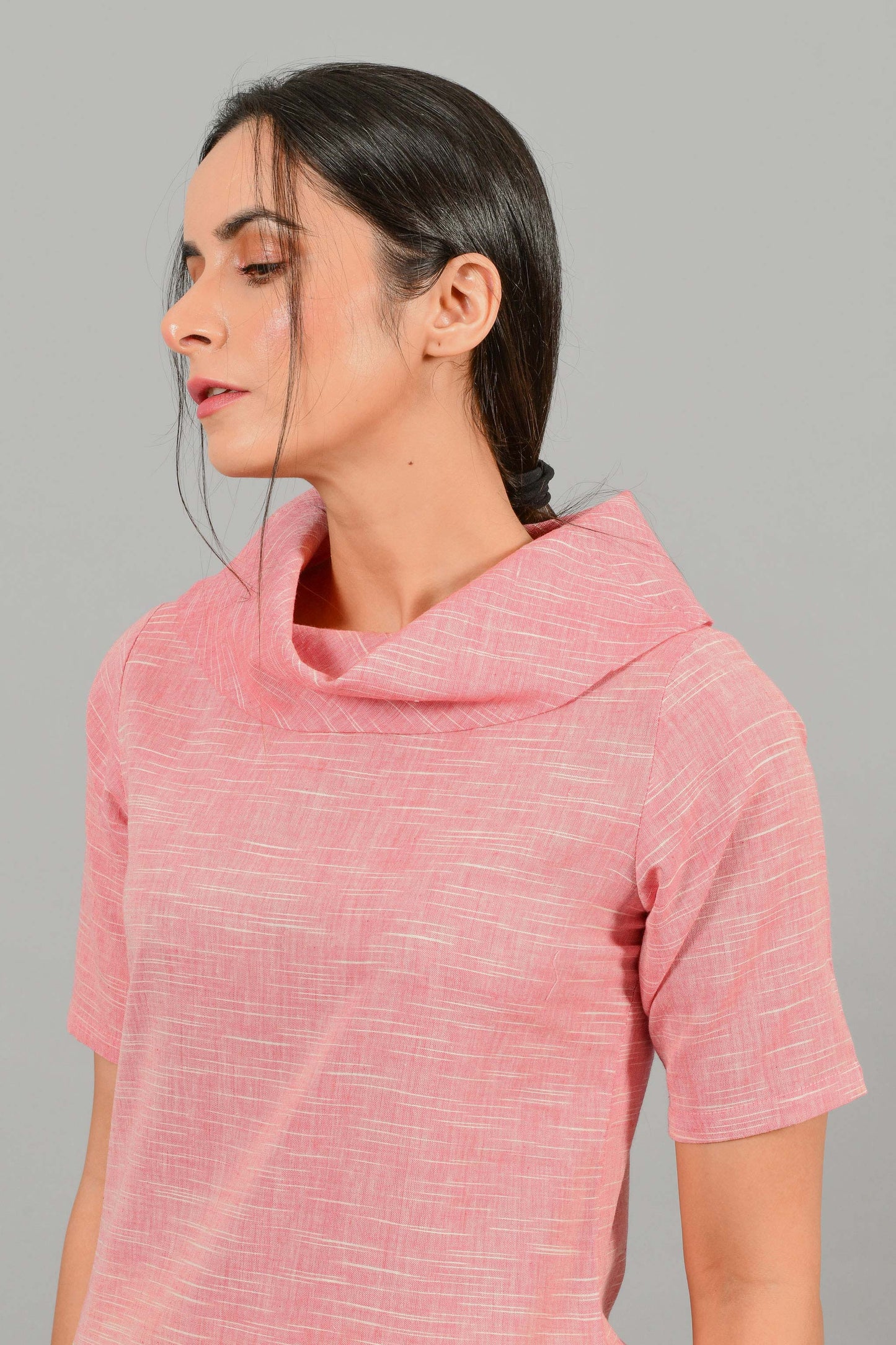 Front portrait pose of an Indian female womenswear fashion model in a Pink and White space dyed cowl neck, elbow sleeve handspun and handwoven khadi cotton dress by Cotton Rack.