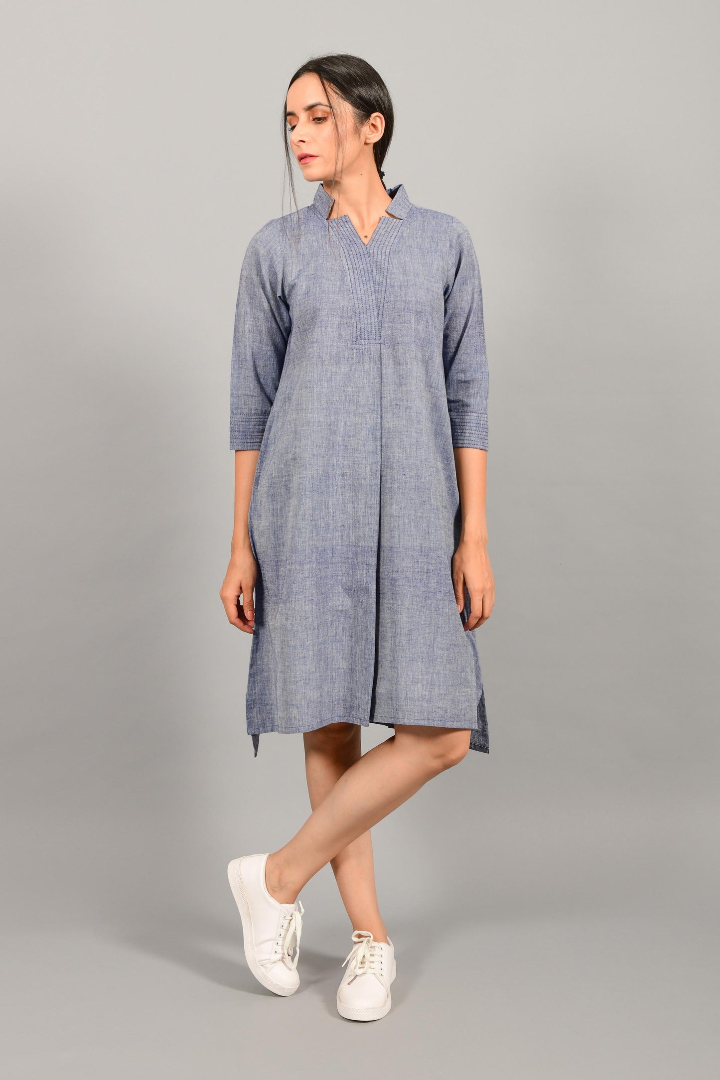 Front pose of an Indian female womenswear fashion model in a blue chambray handspun and handwoven khadi cotton dress-kurta by Cotton Rack.