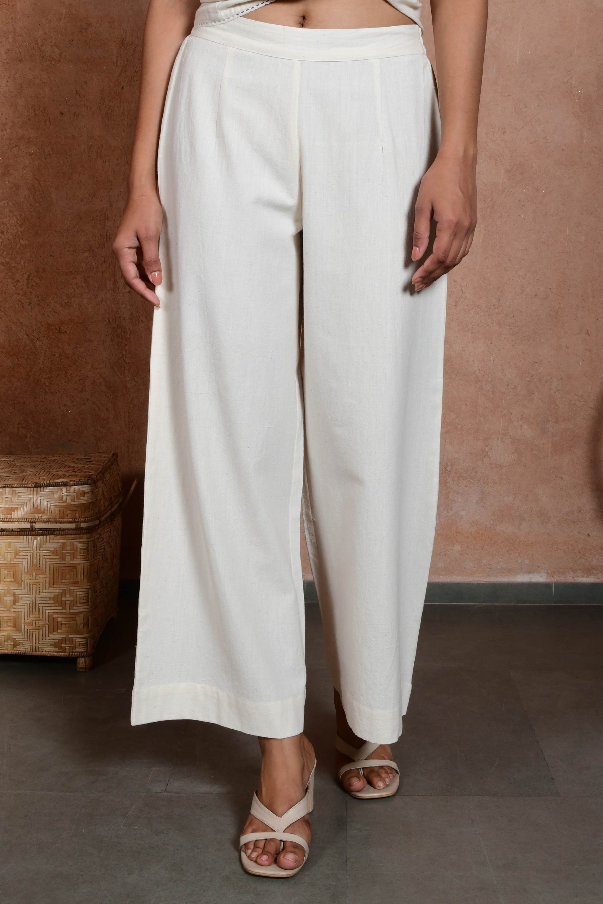 Lower half of the front pose of an indian model wearing off white straight pants.