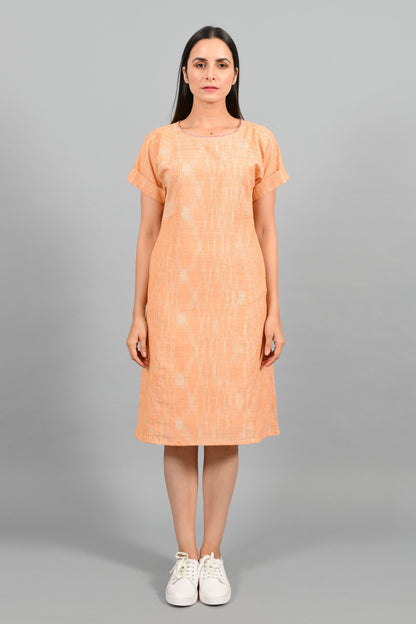 Front pose of an Indian female womenswear fashion model in an orange space dyed handspun and handwoven khadi cotton panelled dress by Cotton Rack.