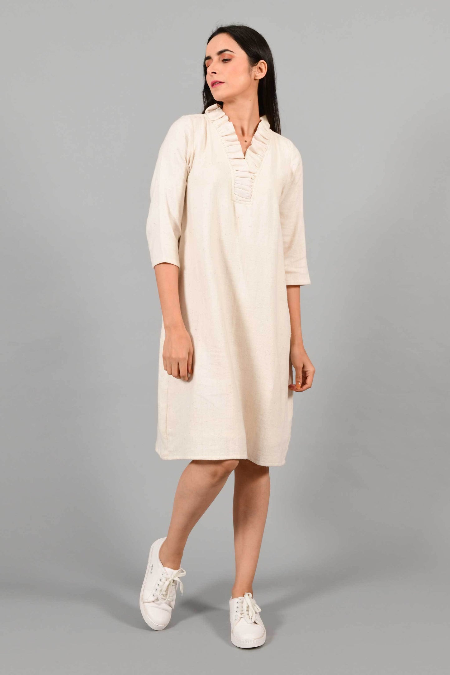 Stylised front pose of an Indian female womenswear fashion model in an off-white Cashmere Cotton Dress with flared neck, made using handspun and handwoven khadi cotton by Cotton Rack.