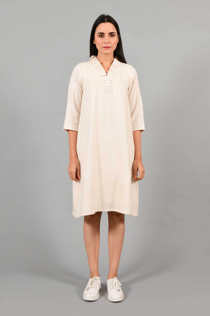 Front pose of an Indian female womenswear fashion model in an off-white Cashmere Cotton Dress with flared neck, made using handspun and handwoven khadi cotton by Cotton Rack.