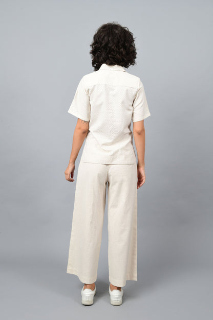 Back of the model wearing off-white relaxed shirt top printed with fine blue dots printed using metal block by Cotton Rack inspired by artist agnes martin.