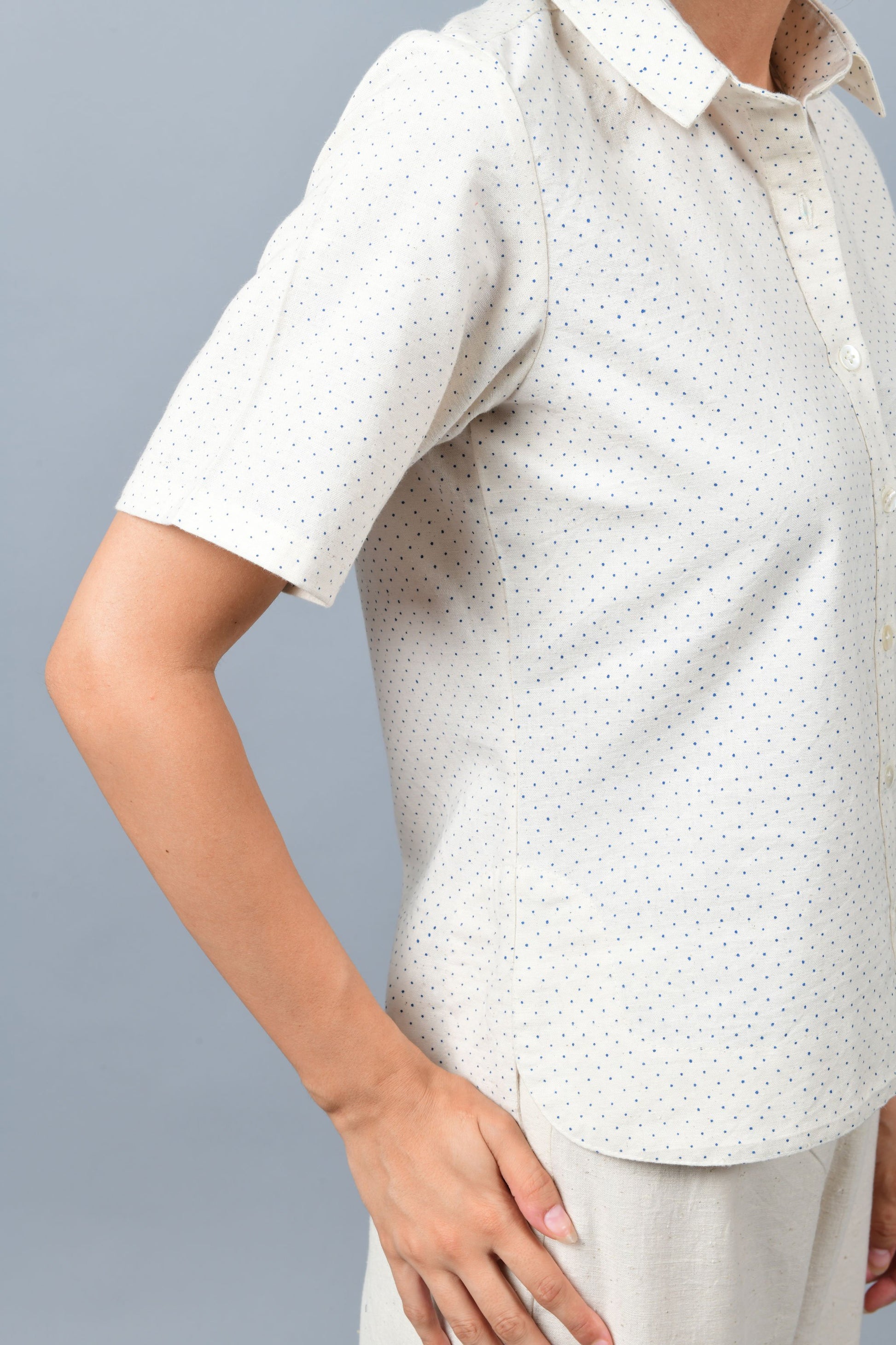 Close up of the model wearing off-white Khadi cotton relaxed shirt top printed with fine blue dots printed using metal block by Cotton Rack inspired by artist agnes martin.