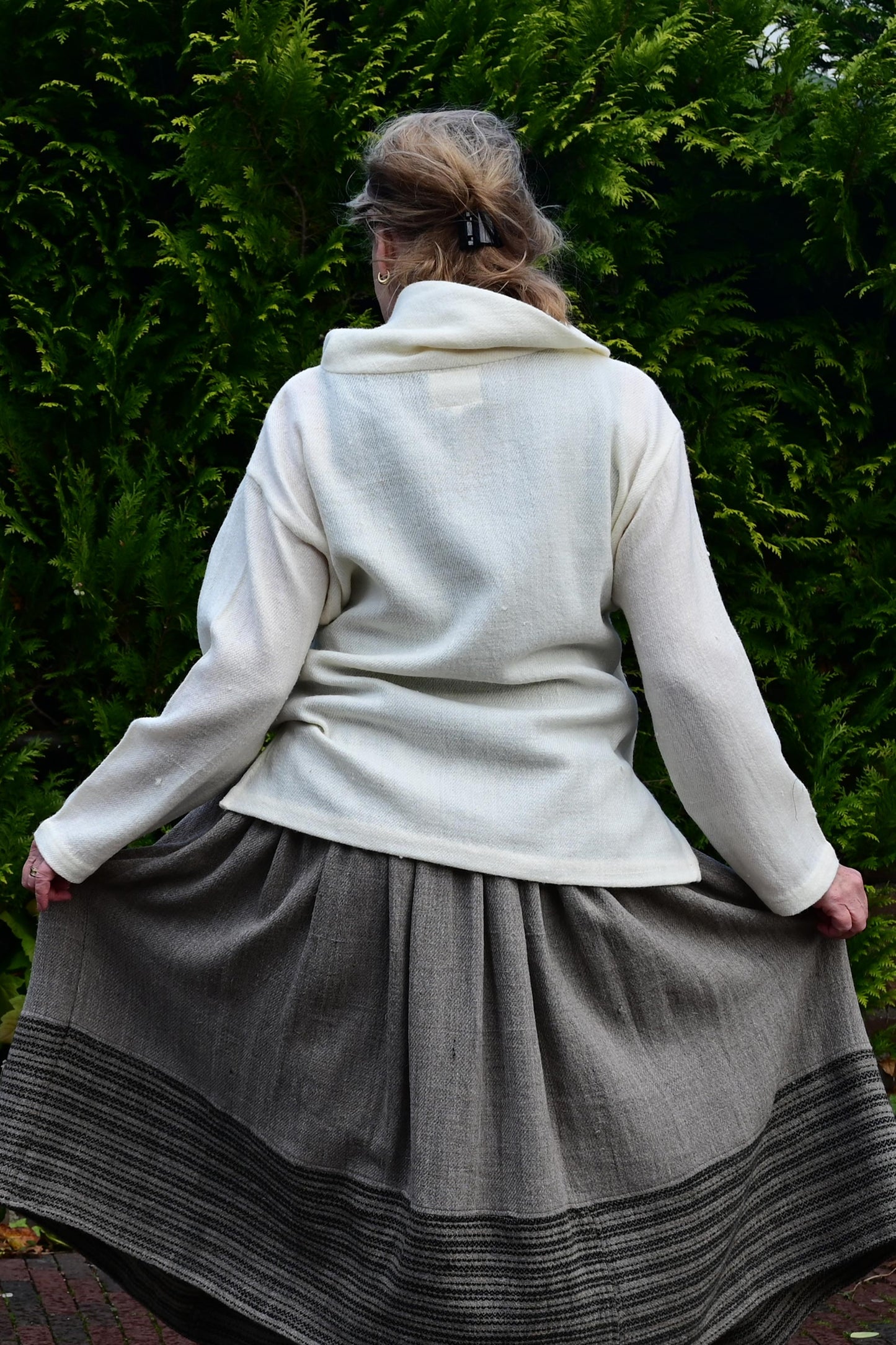 back pose of a model showing off a Ivory white cowl neck woolen top made with indigenous Indian wool from Rajasthan. Perfect premium winter clothing for women.