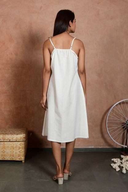 Back pose of an indian model wearing an off white spaghetti slip dress made with handspun handloom cotton.