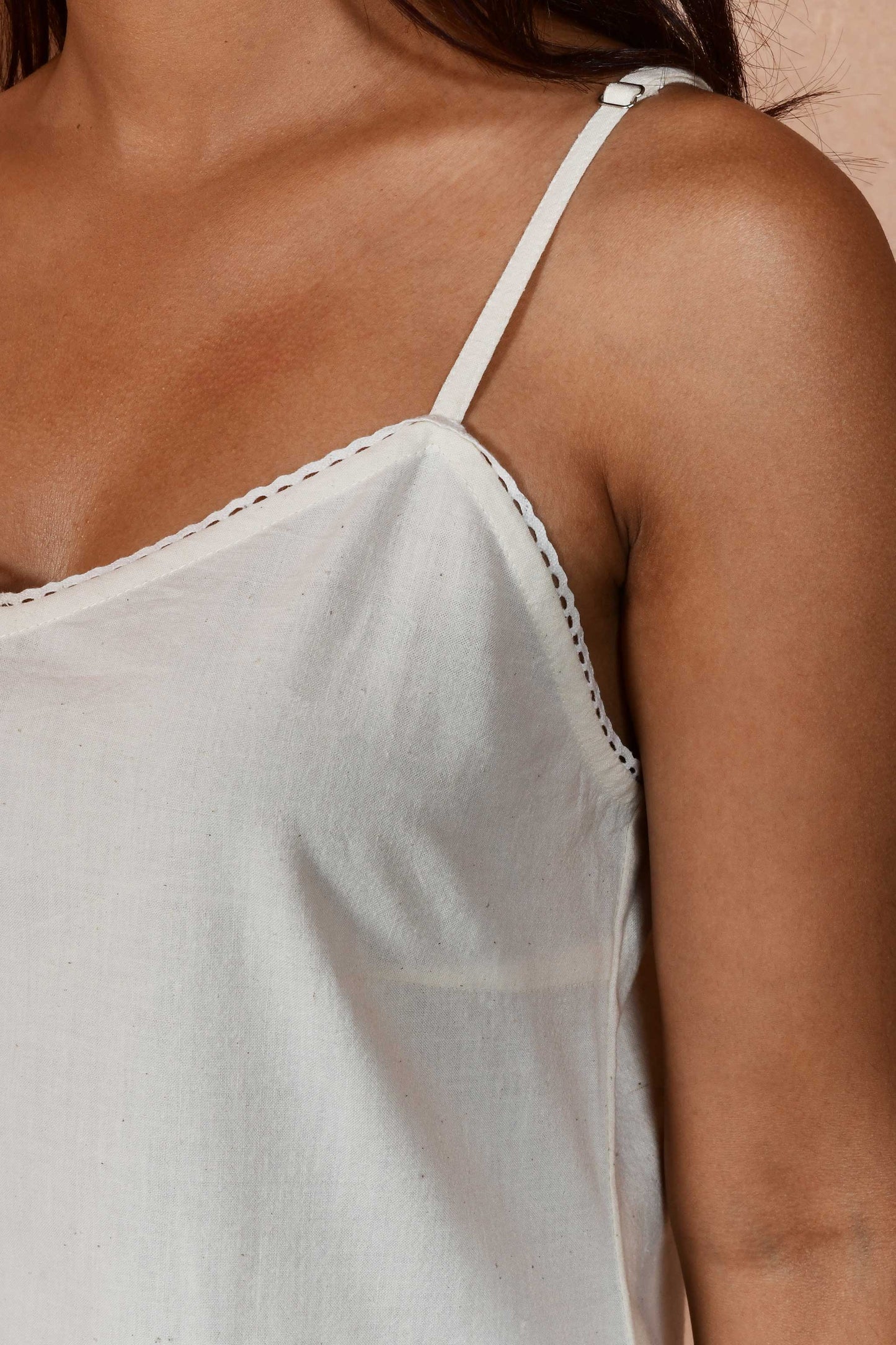 Close up of sweet heart neckline with a lace detail of an off white slip dress. 