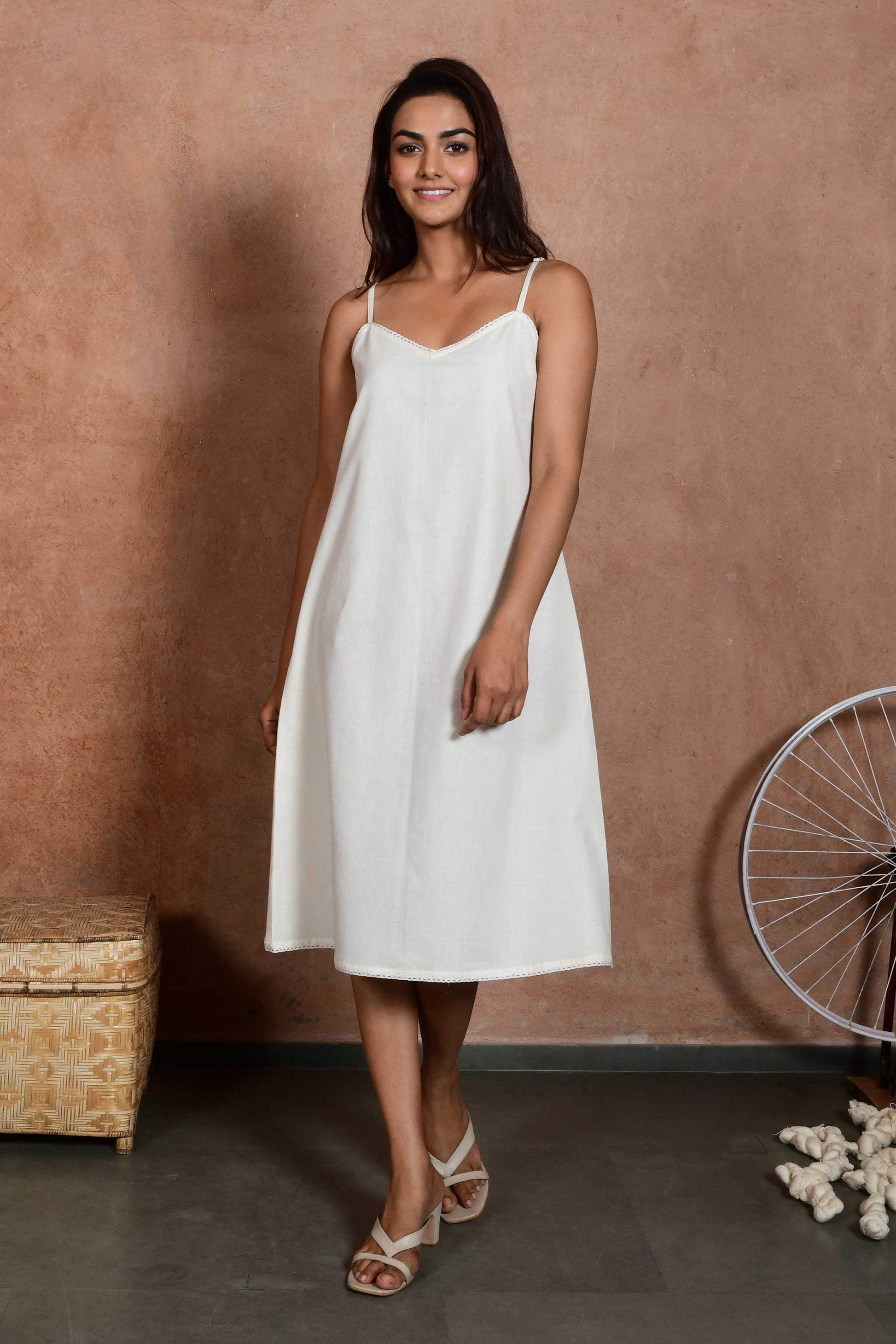 Front pose of an indian model wearing an off white spaghetti slip dress made with handspun handloom cotton.